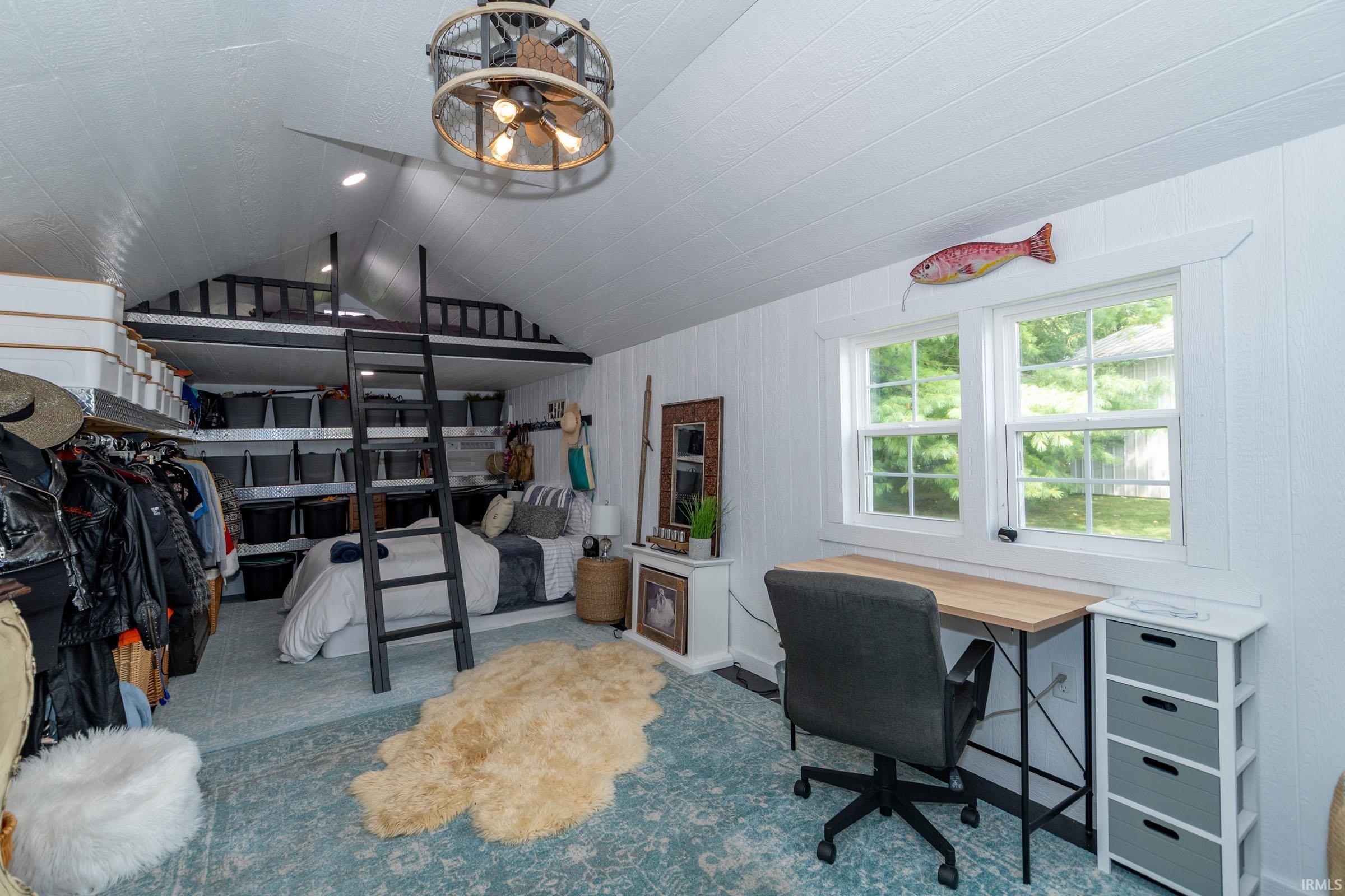 Vaulted ceiling with shiplap finish and ceiling fan