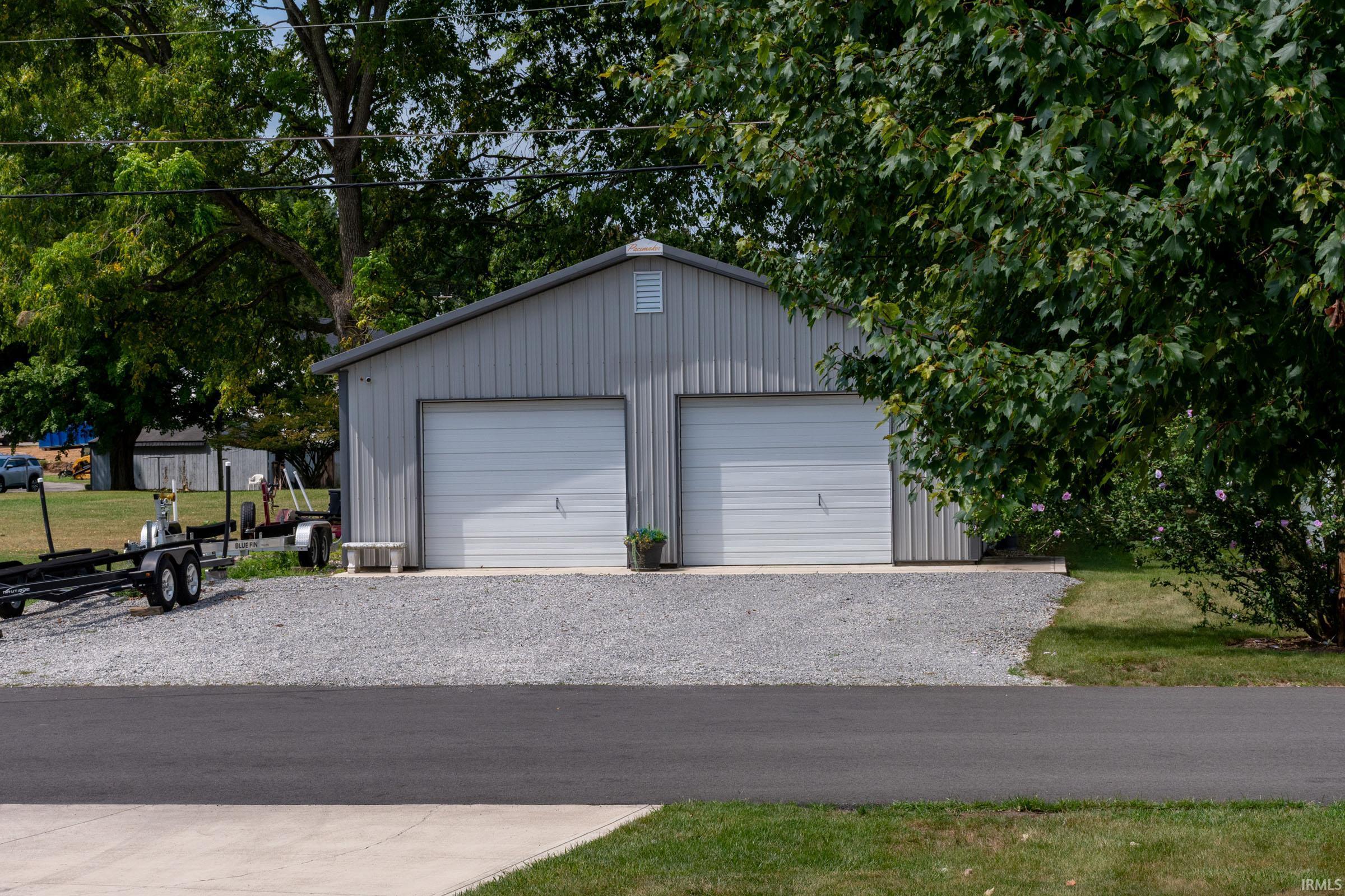 Two-car garage with corrugated metal siding and white overhead doors