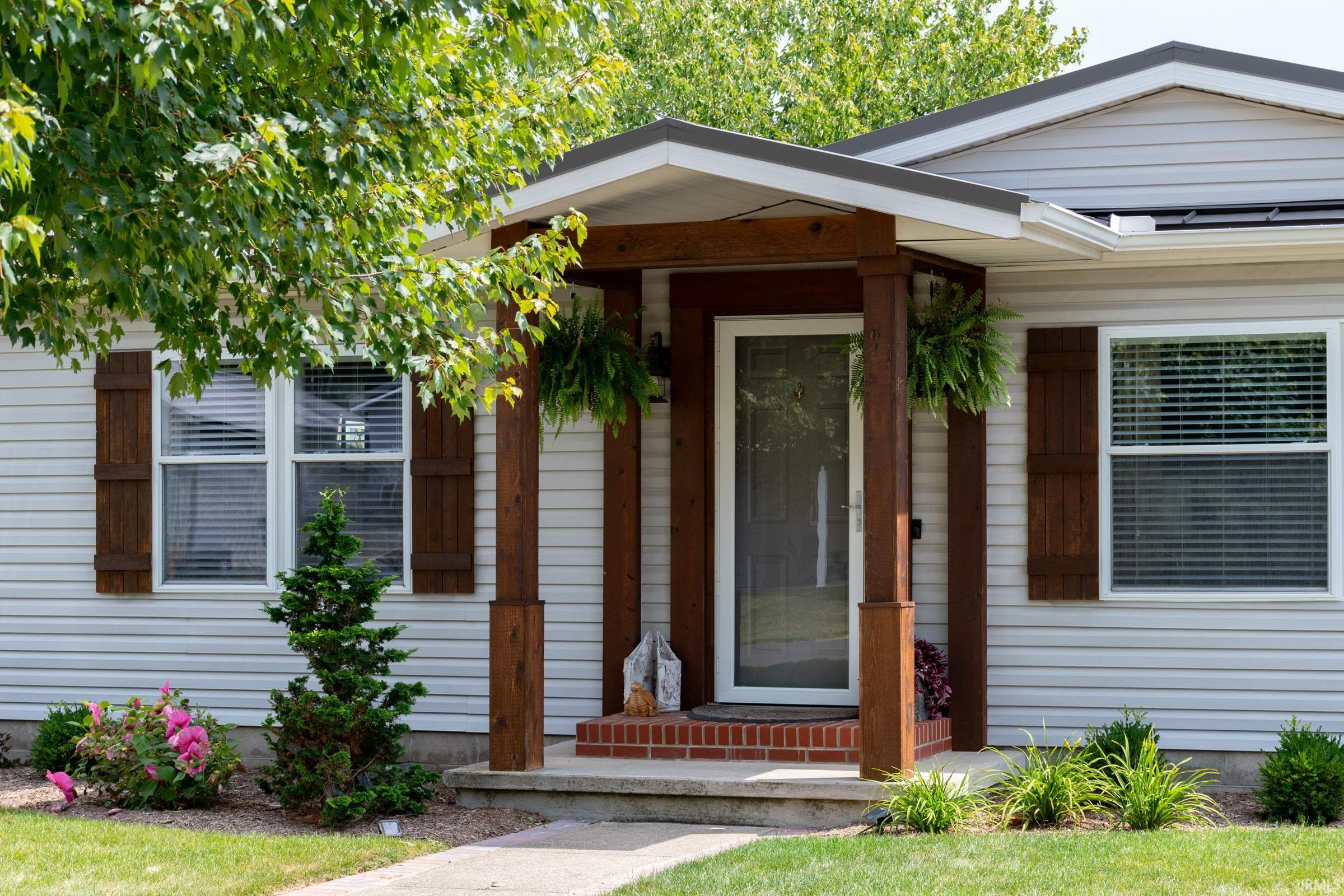Front entry featuring a wood-finish columned porch with a pitched roof