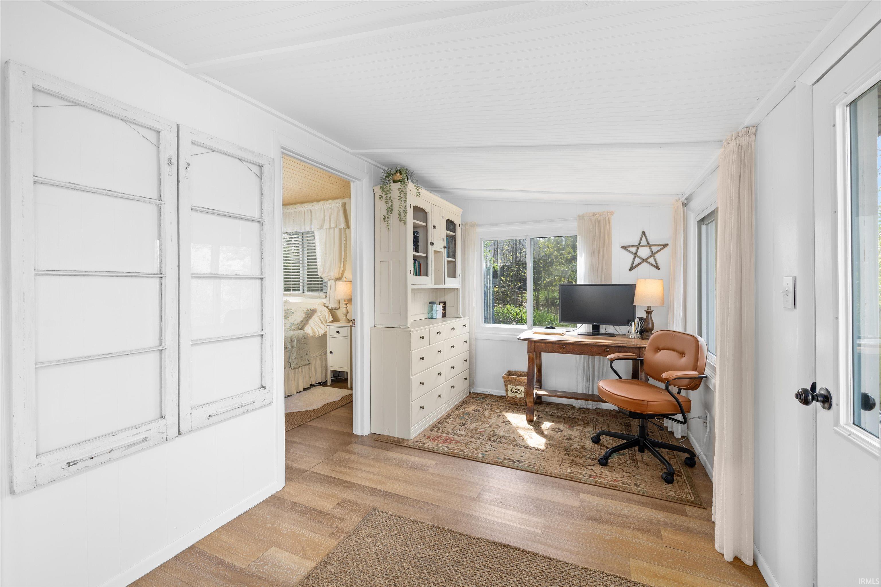 Bright room with wood-finish flooring and white paneled walls