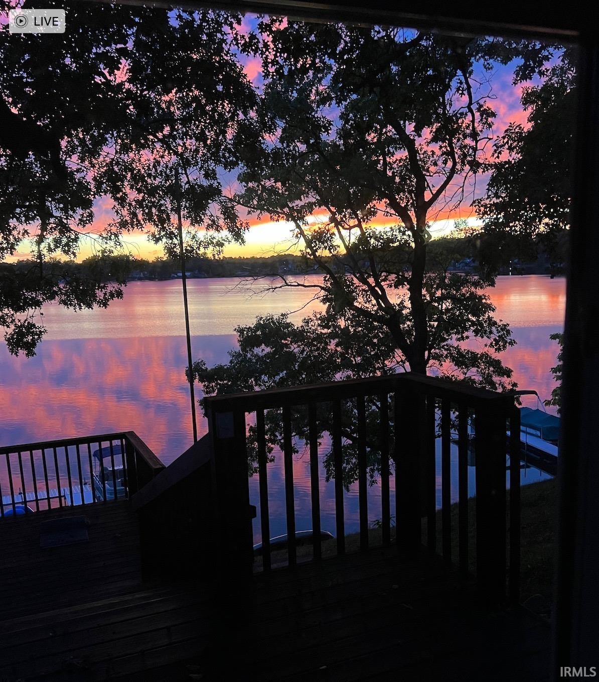 Expansive waterfront scenery with mature trees and a multi-level wood deck