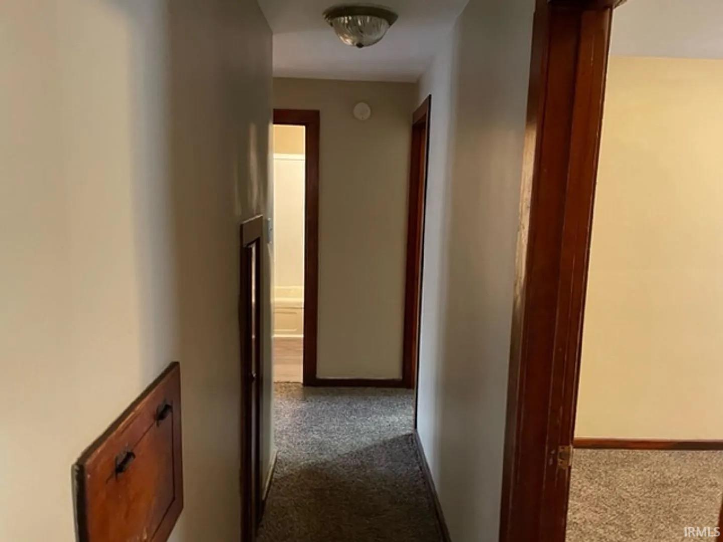 Hallway with carpet flooring and light-toned walls
