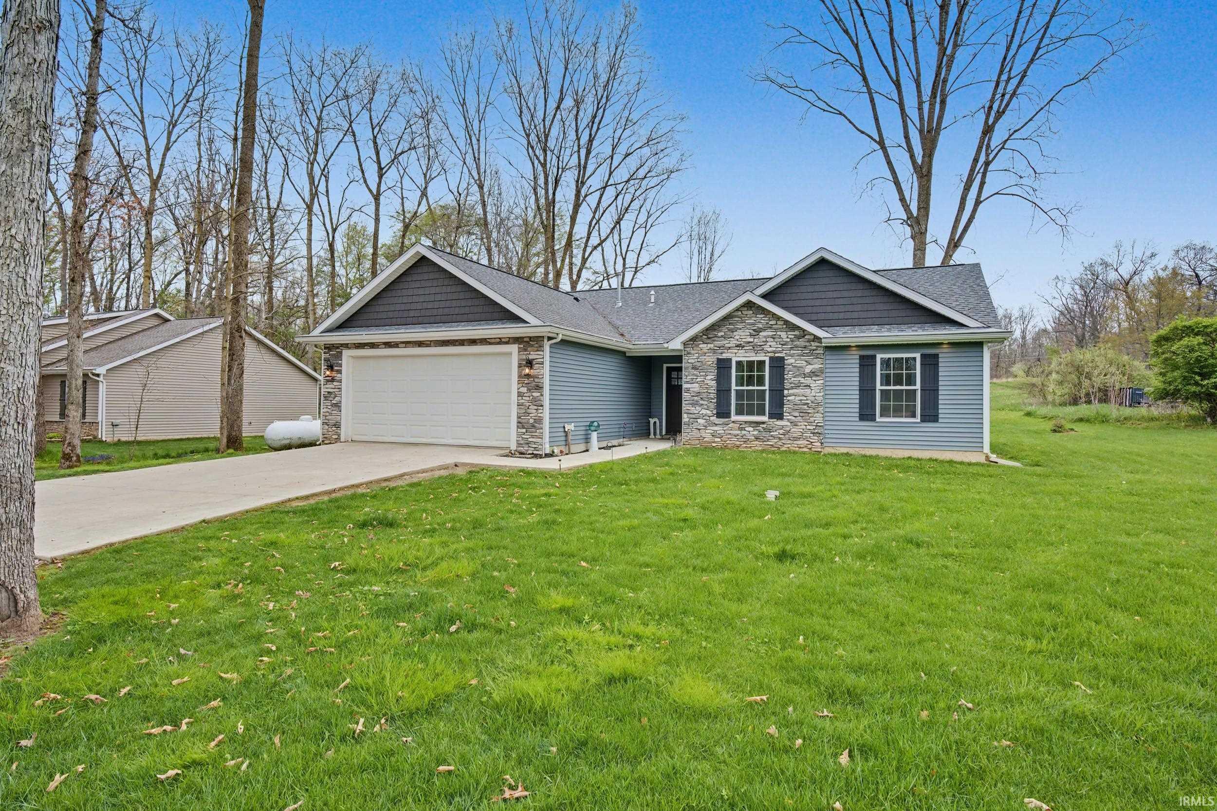 Ranch-style exterior featuring blue siding and stone accents