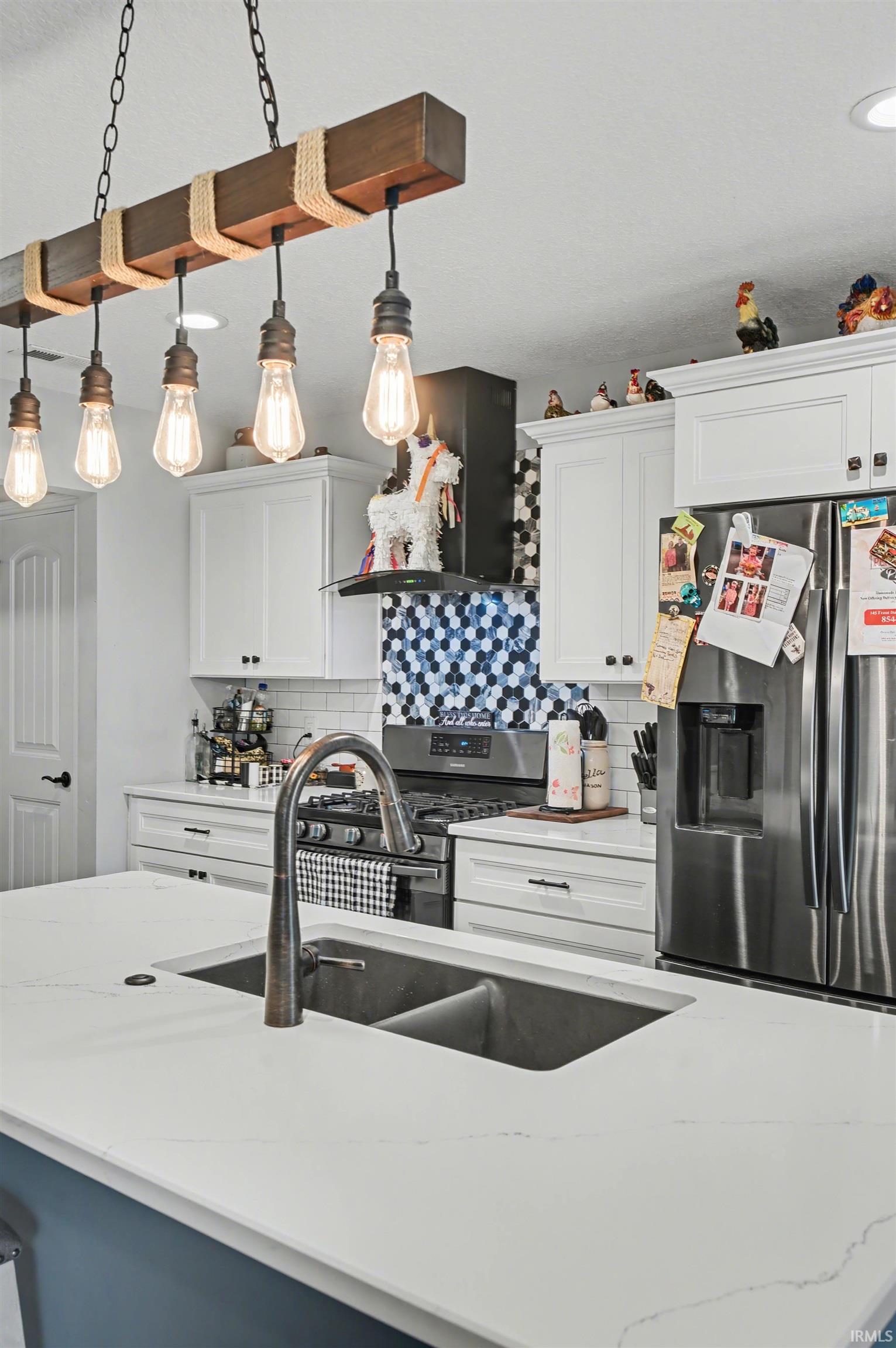 Kitchen island with a dual-basin undermount sink, gooseneck faucet, and light-toned countertops
