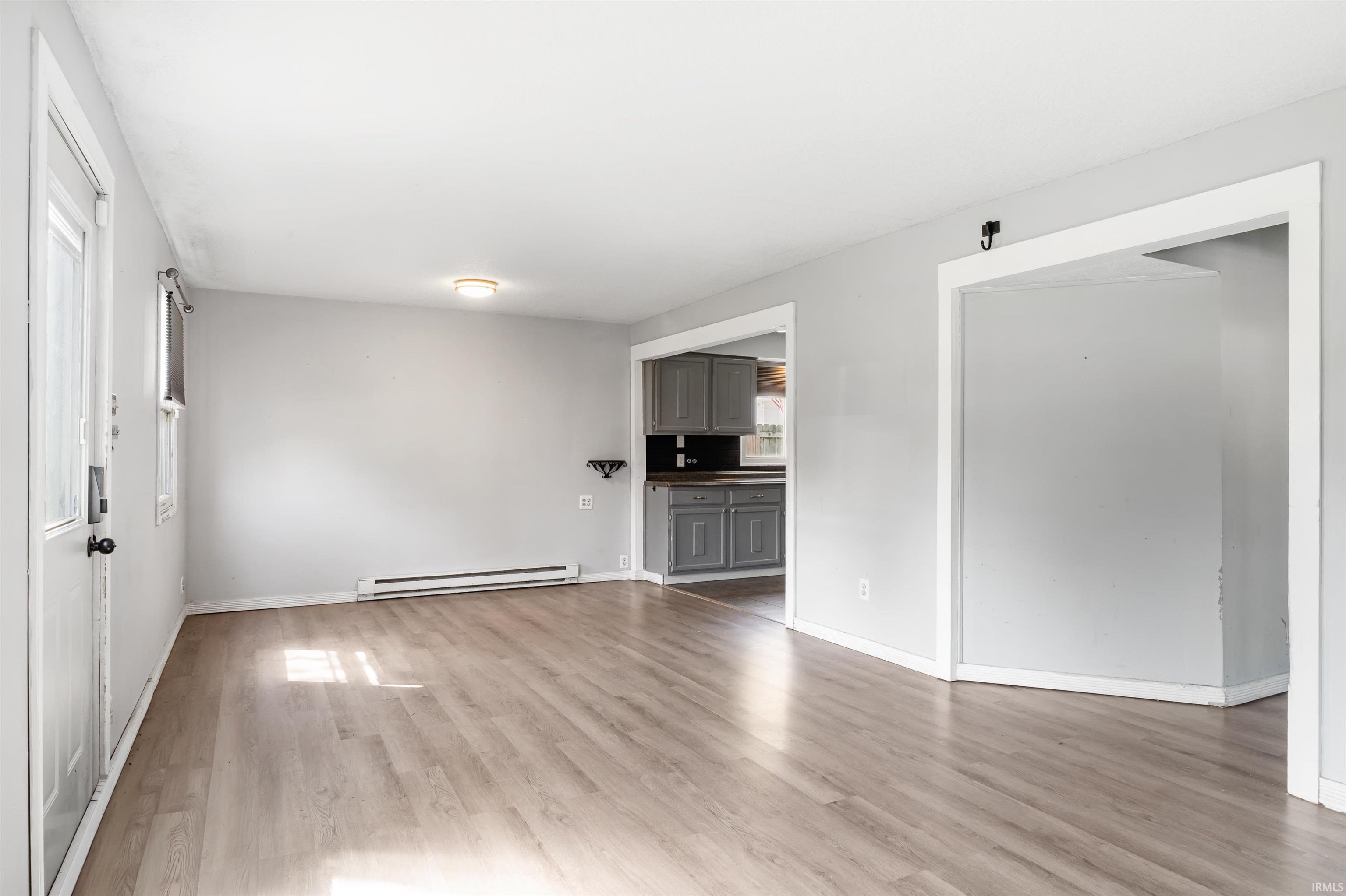 Open concept living area featuring wood-finish flooring, light gray walls, and recessed lighting