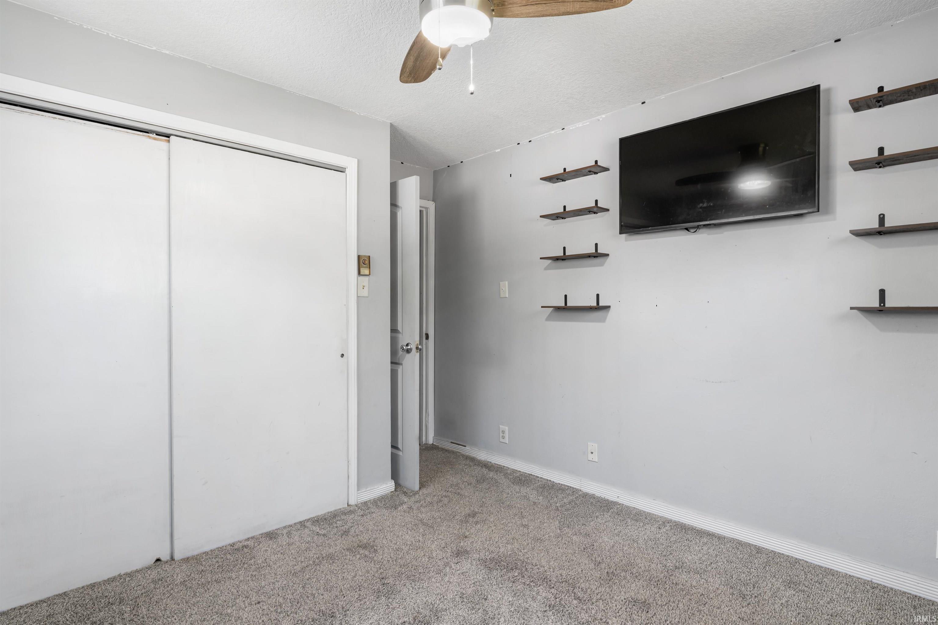 Interior room featuring gray carpet flooring and light gray painted walls
