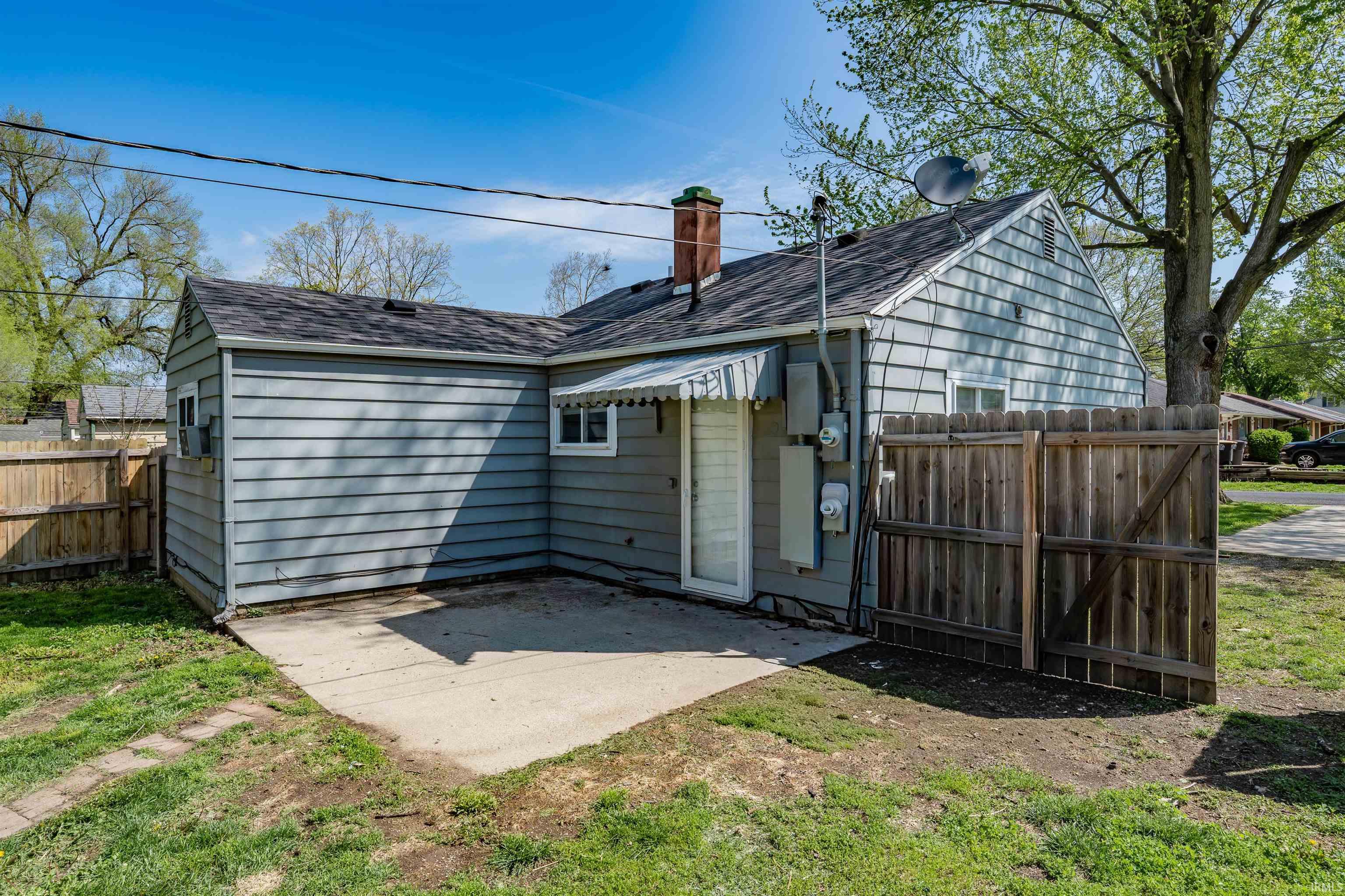 Rear exterior featuring light grey siding and a concrete patio