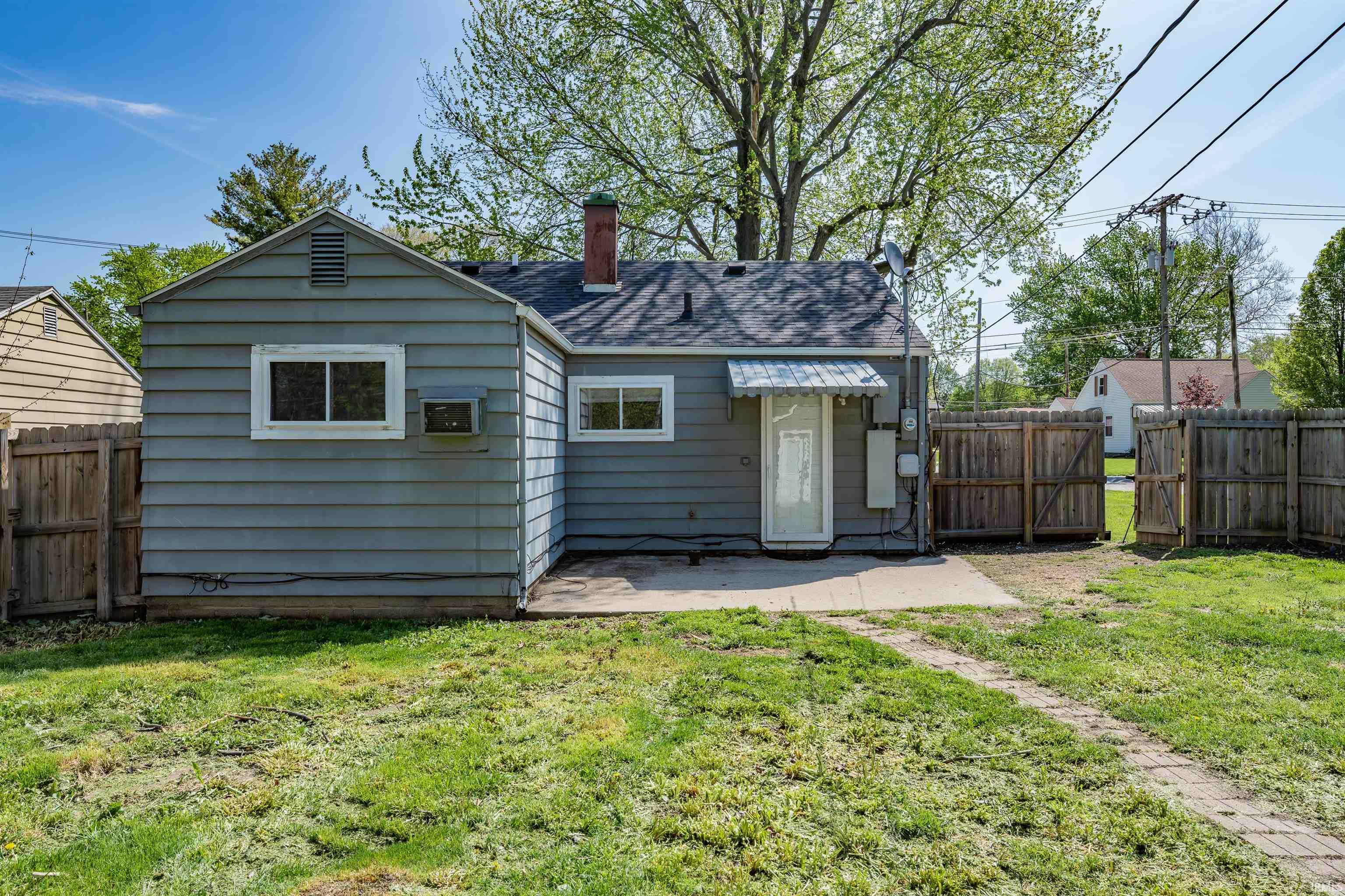 Rear exterior featuring horizontal siding, a gabled roofline, and a concrete patio