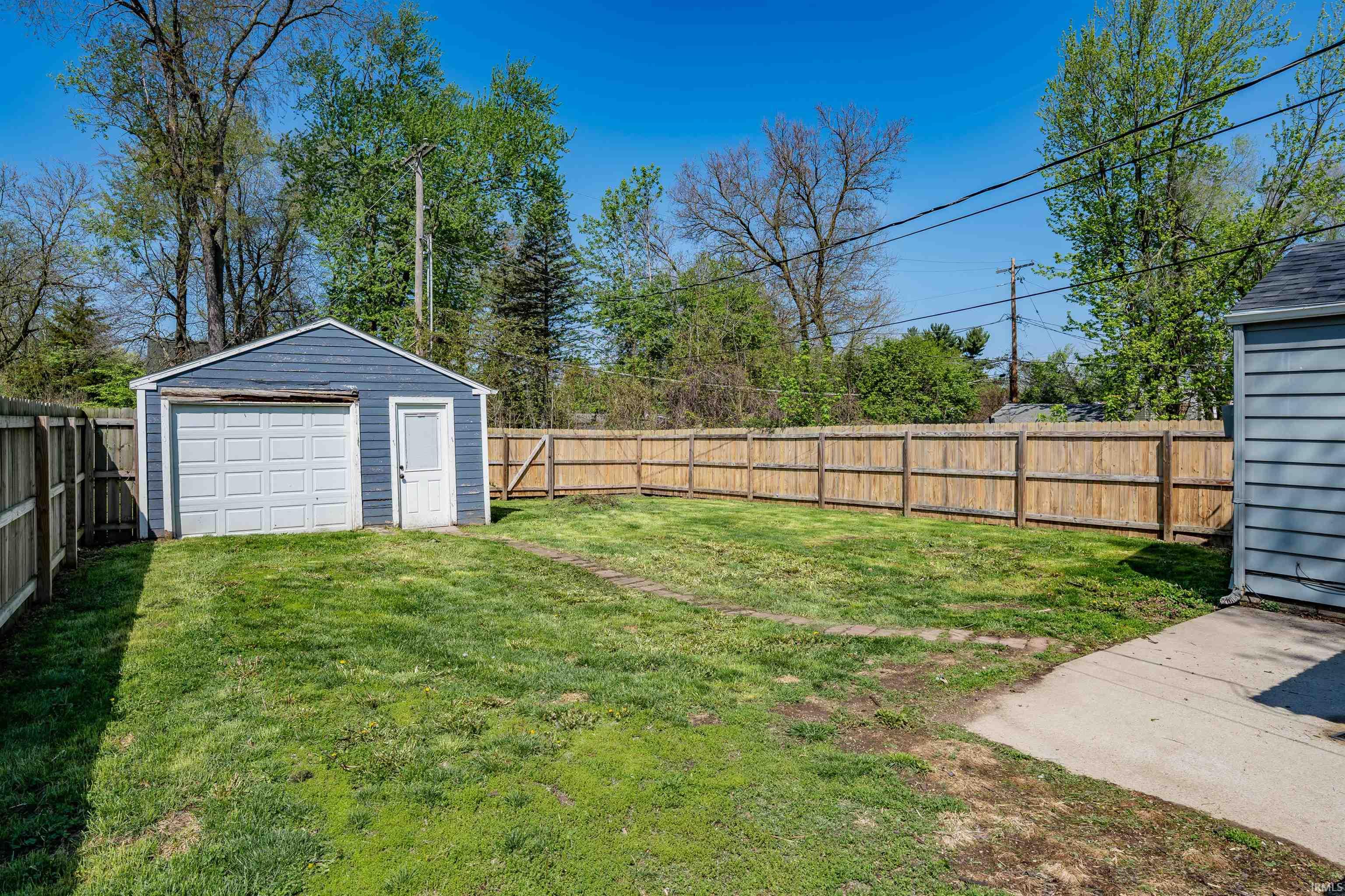 Detached garage with horizontal siding and an overhead door