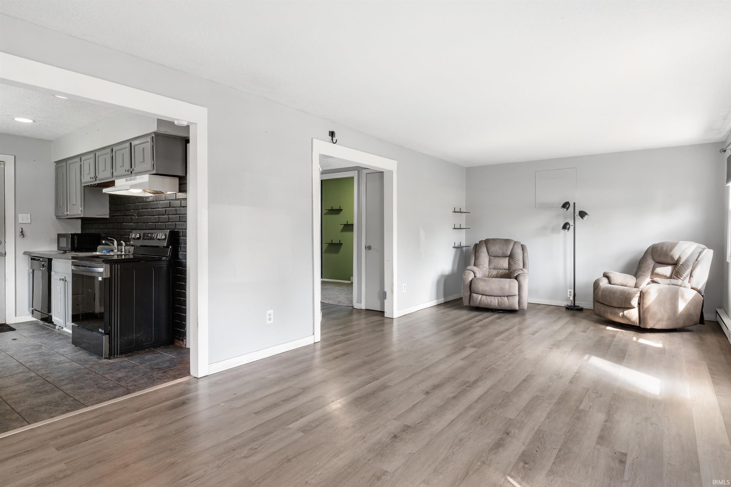 Spacious main living area featuring wood-finish flooring, light gray wall paint, and white trim