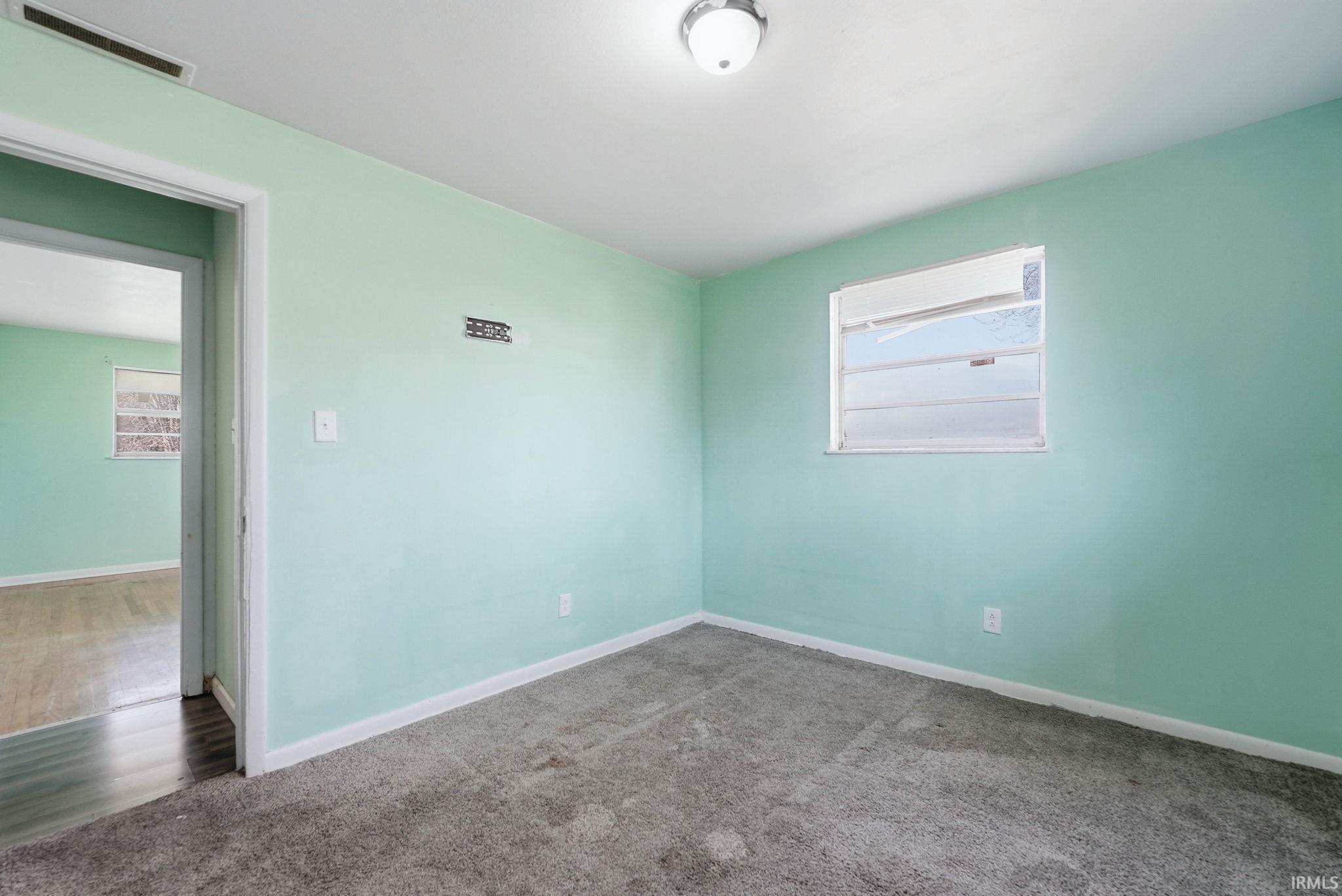 Interior room with light green walls and gray carpeting