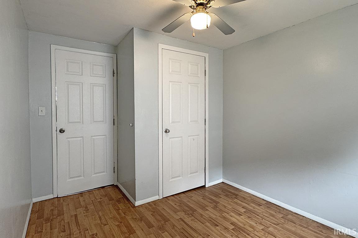 Interior room featuring wood-finish flooring, light grey painted walls, and white trim