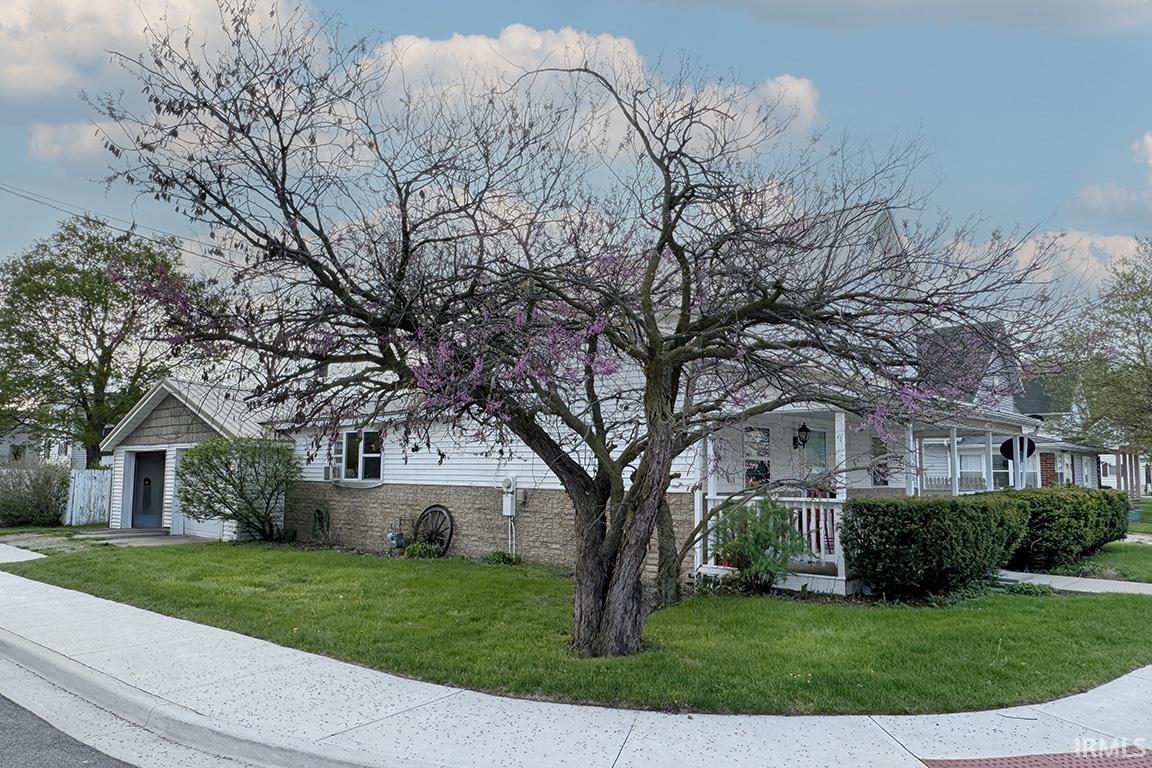 Corner lot property featuring a white siding exterior with a stone foundation