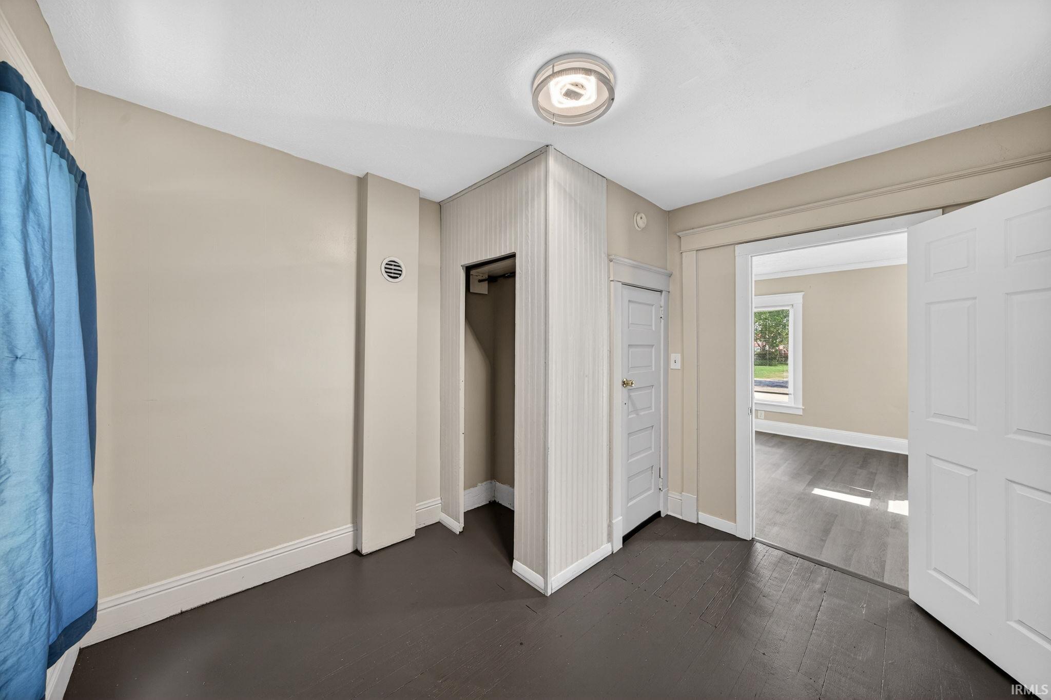 Neutral tone wall paint with dark wood-finish flooring