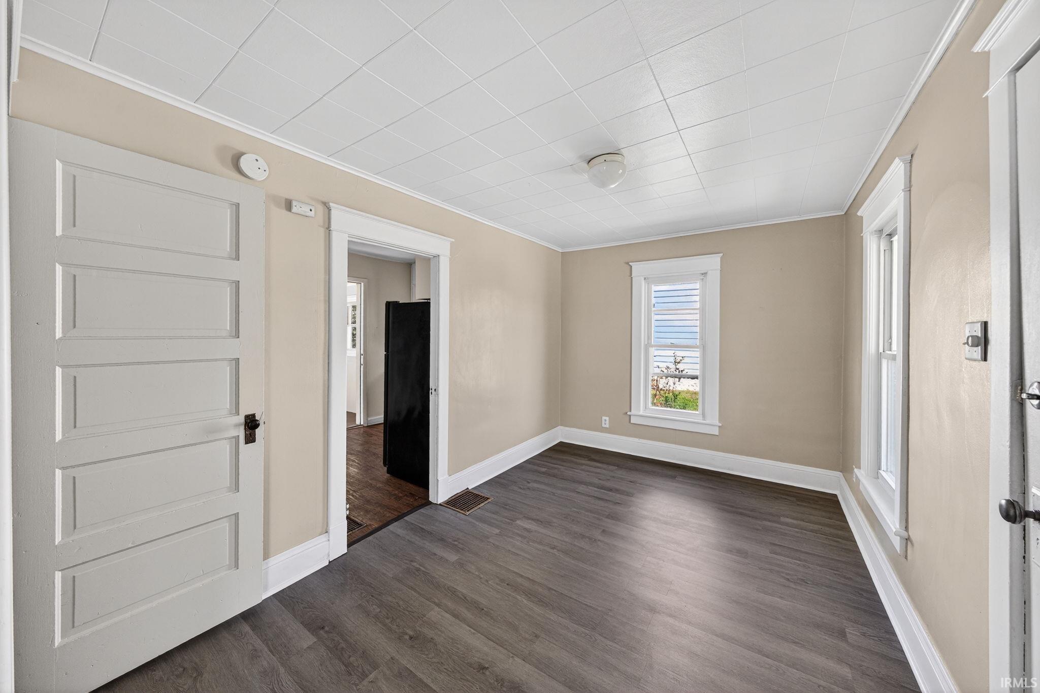 Living room featuring vinyl plank flooring, neutral wall paint, and white trim