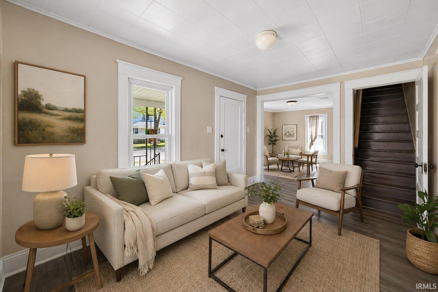 Living area with wood-finish flooring, light-toned wall paint, white trim, and a white paneled ceiling