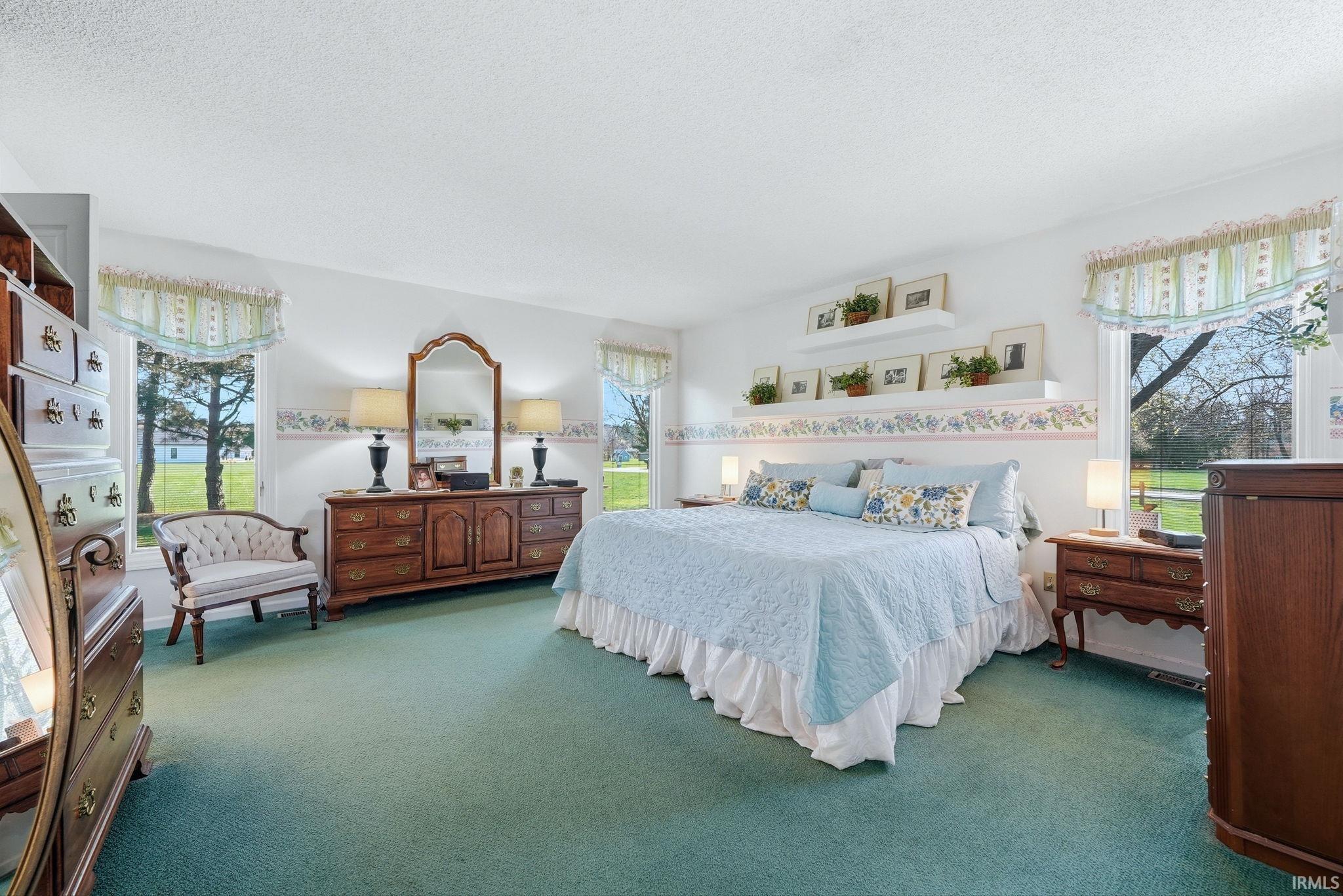 Bedroom featuring dark colored carpet and a textured ceiling