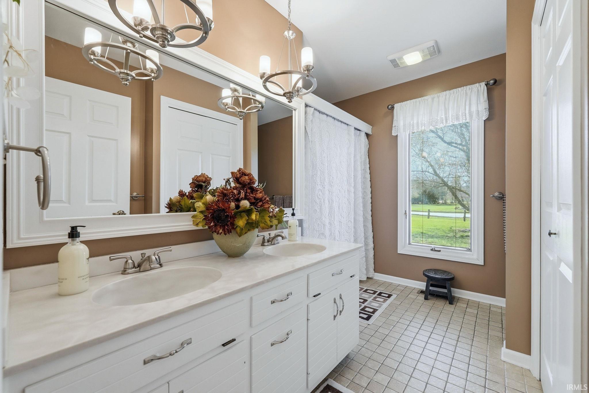 Full bathroom featuring double vanity and light tile patterned floors