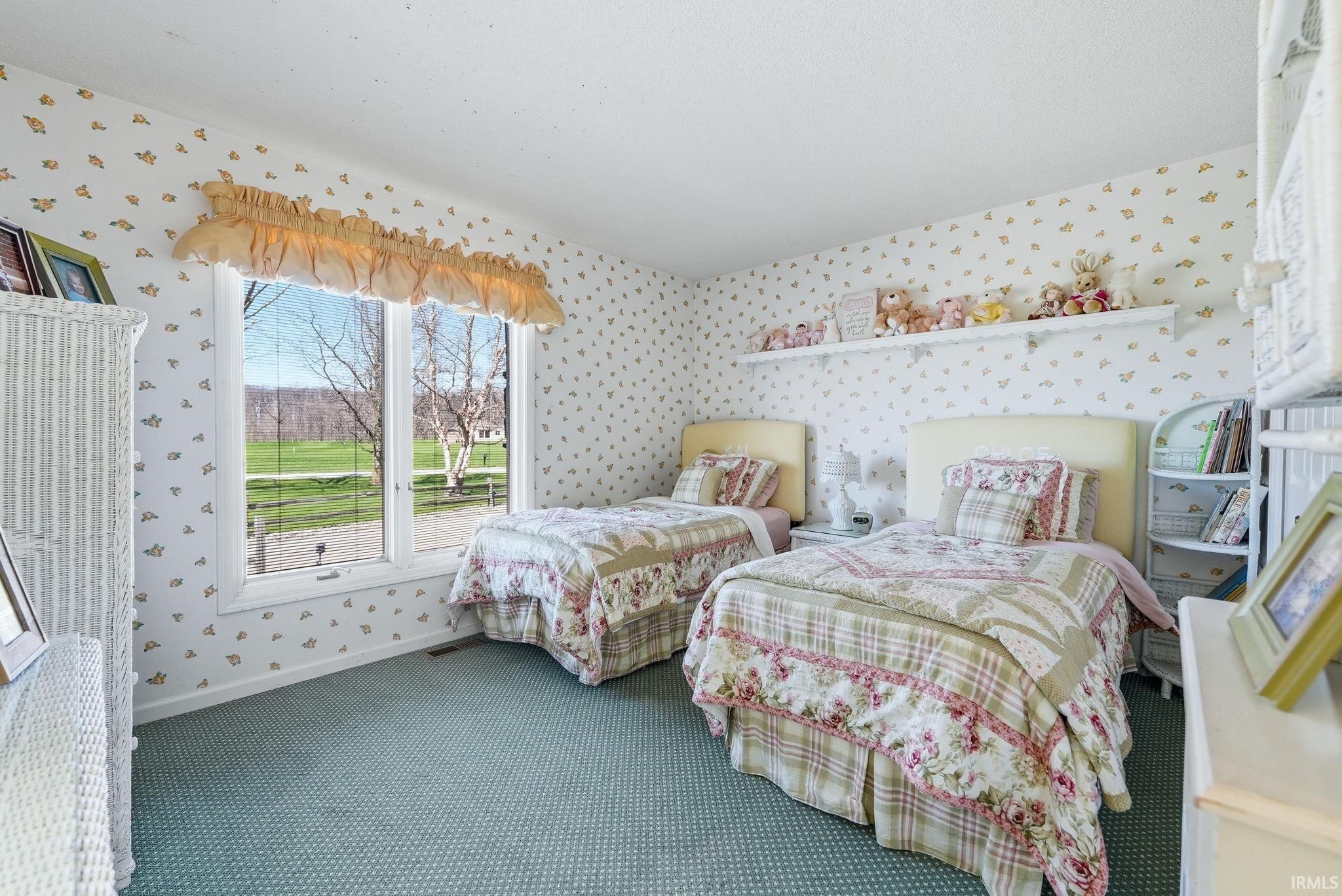 Carpeted bedroom with wallpapered walls and baseboards