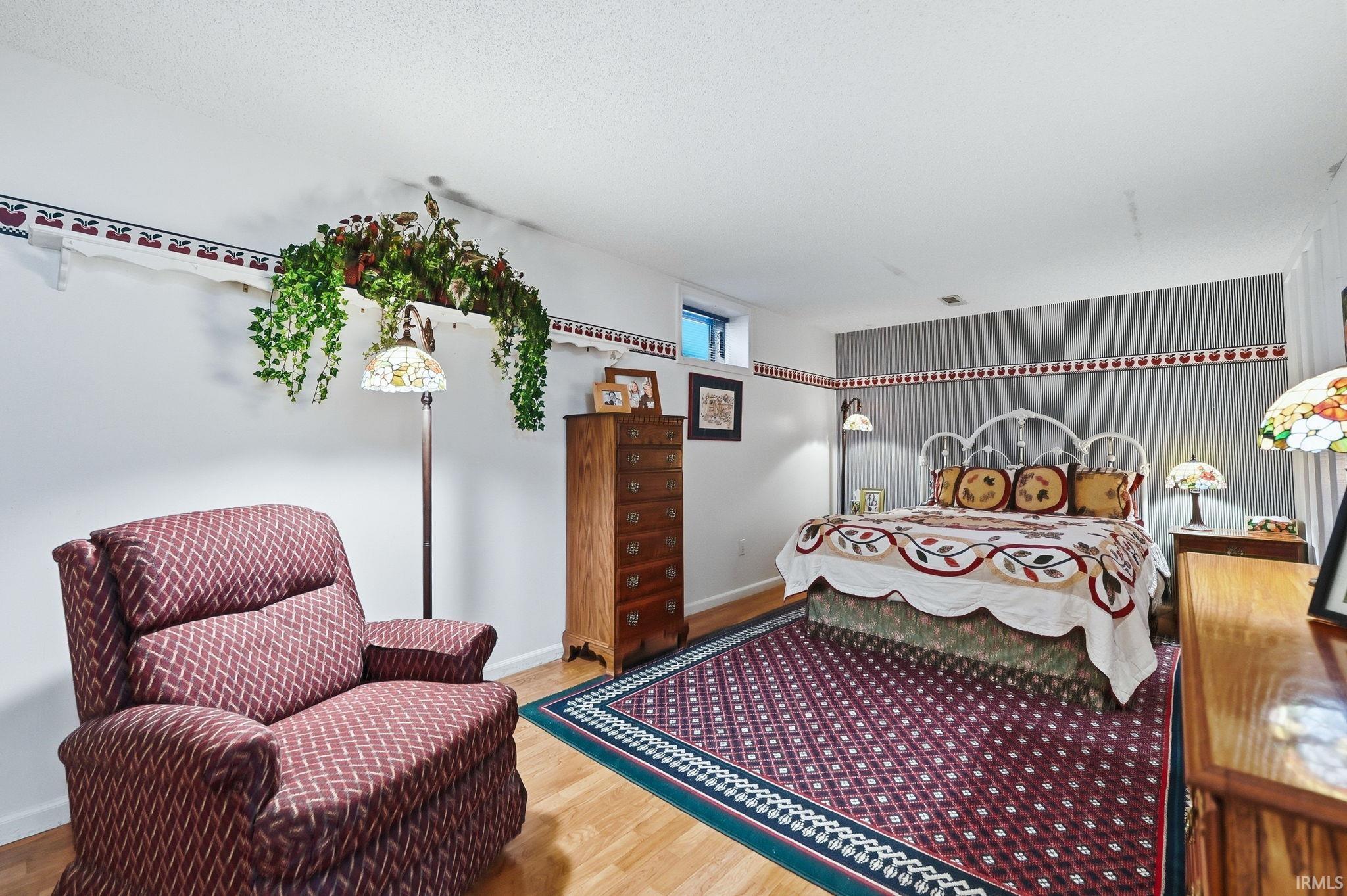 Bedroom with light wood-style floors and an accent wall