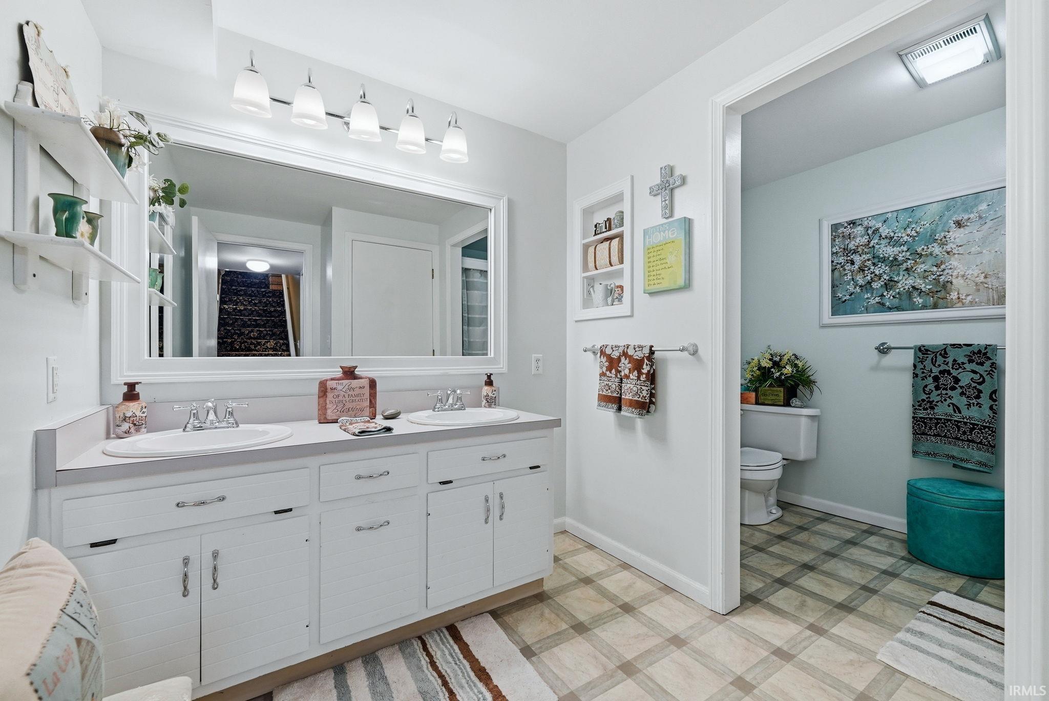 Bathroom featuring light flooring and double vanity