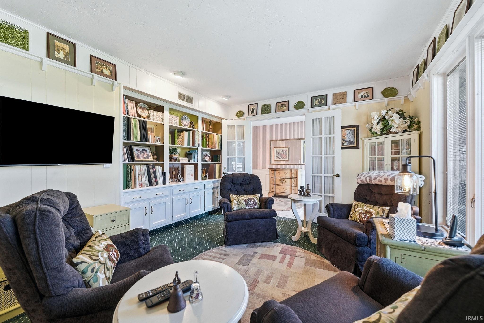 Den featuring carpet and built in shelves