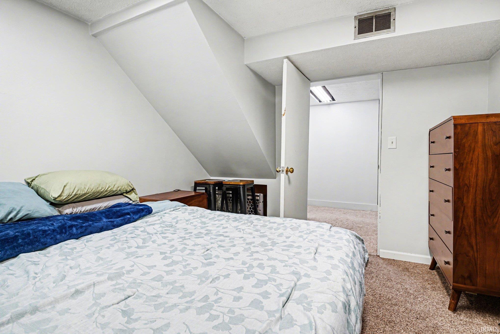 Bedroom featuring light carpet and baseboards