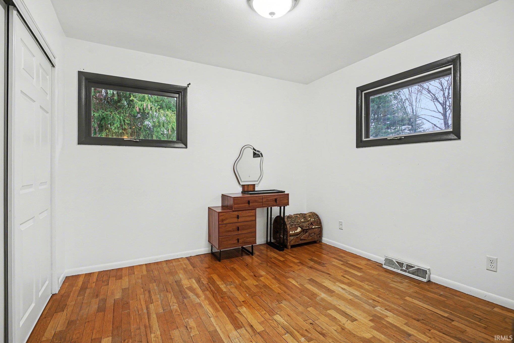 Unfurnished office featuring hardwood / wood-style flooring and baseboards