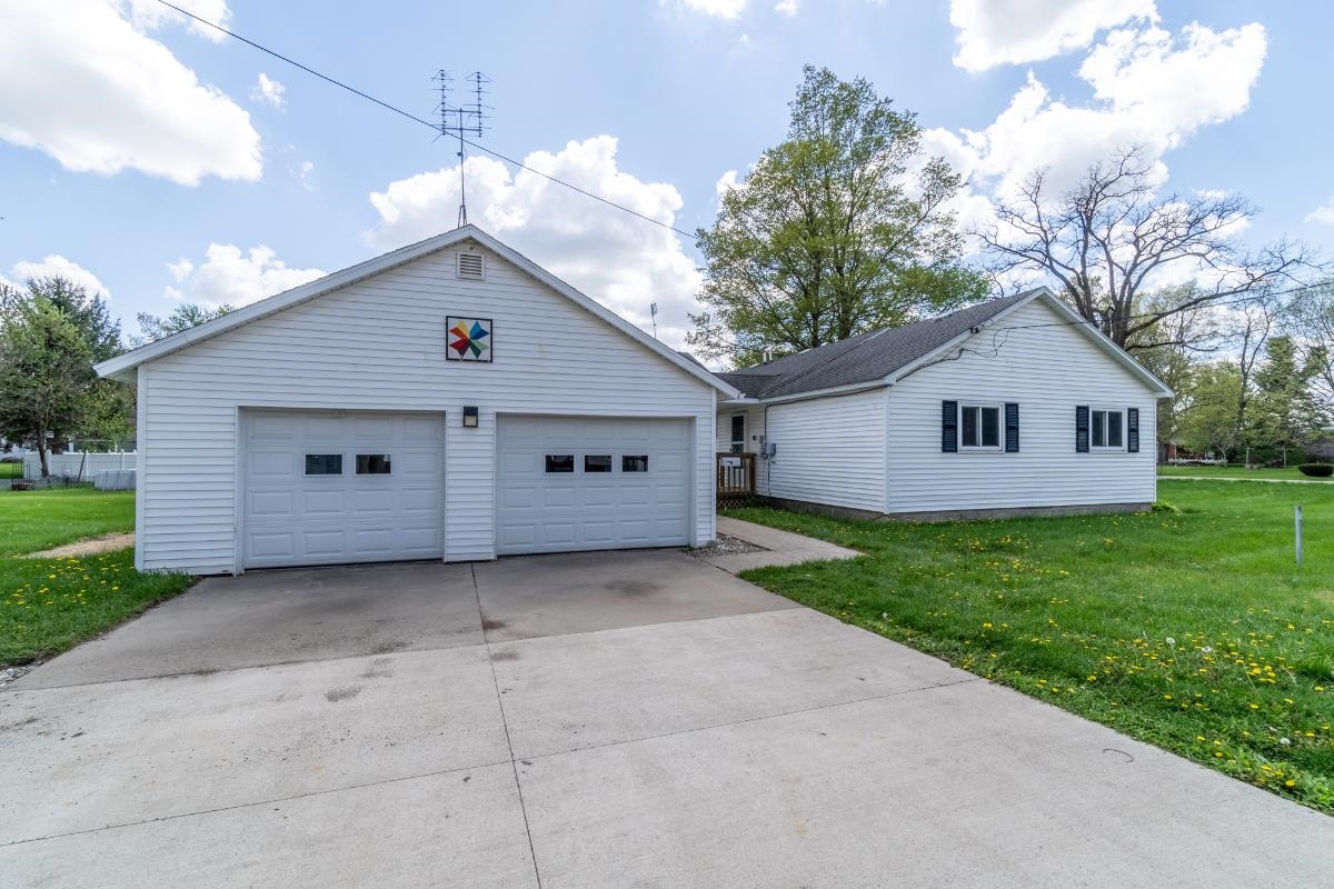 Two-car garage with white vinyl siding and a concrete driveway