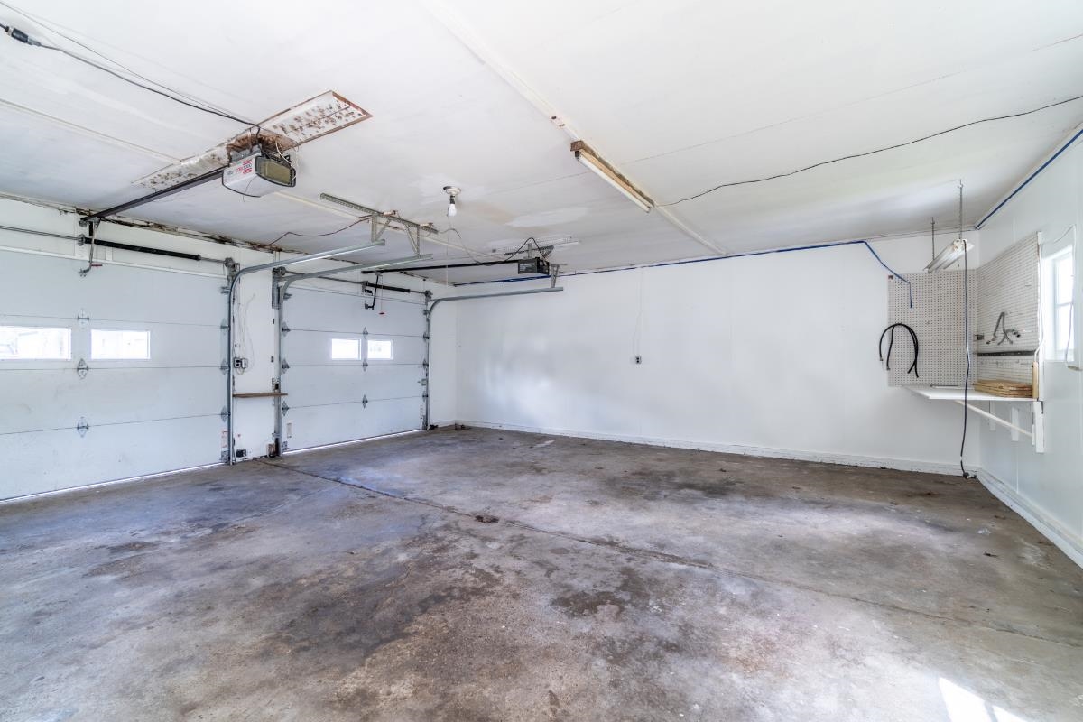 Two-car garage featuring concrete flooring, white walls, and two overhead garage doors with window inserts