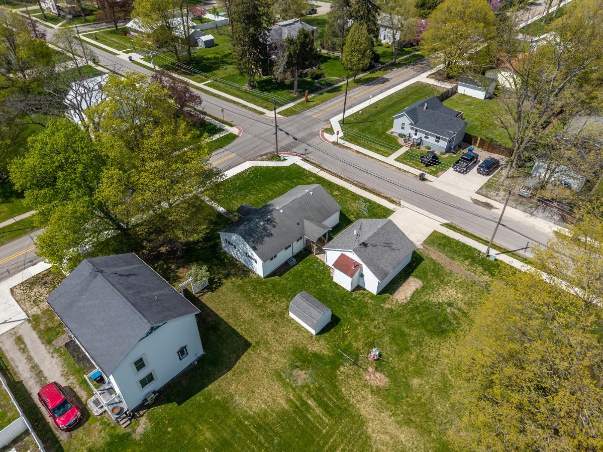 Aerial perspective showcasing multiple residential properties, expansive green spaces, and a clear street grid
