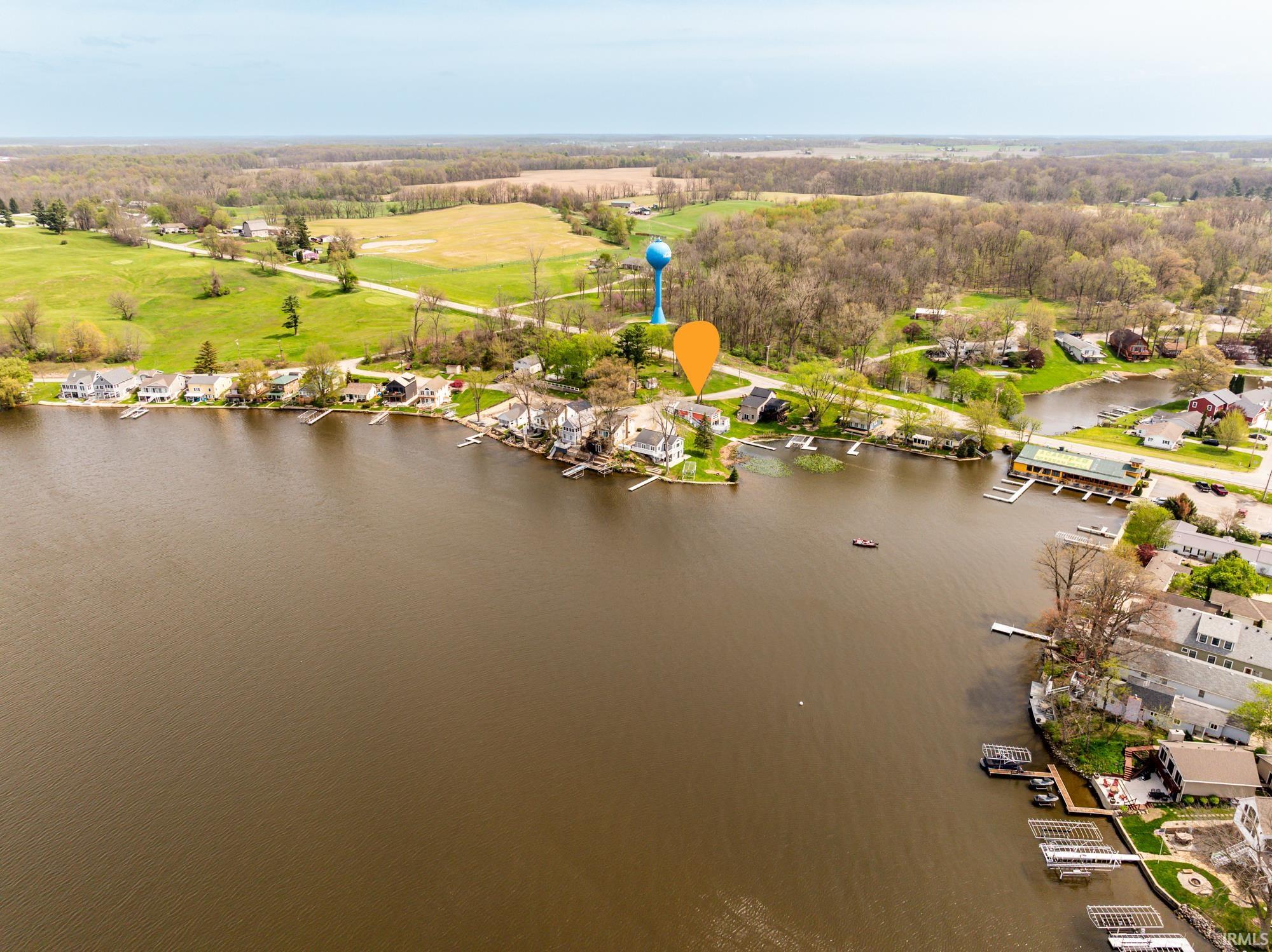 Aerial perspective of a lakeside community featuring multiple properties with private docks