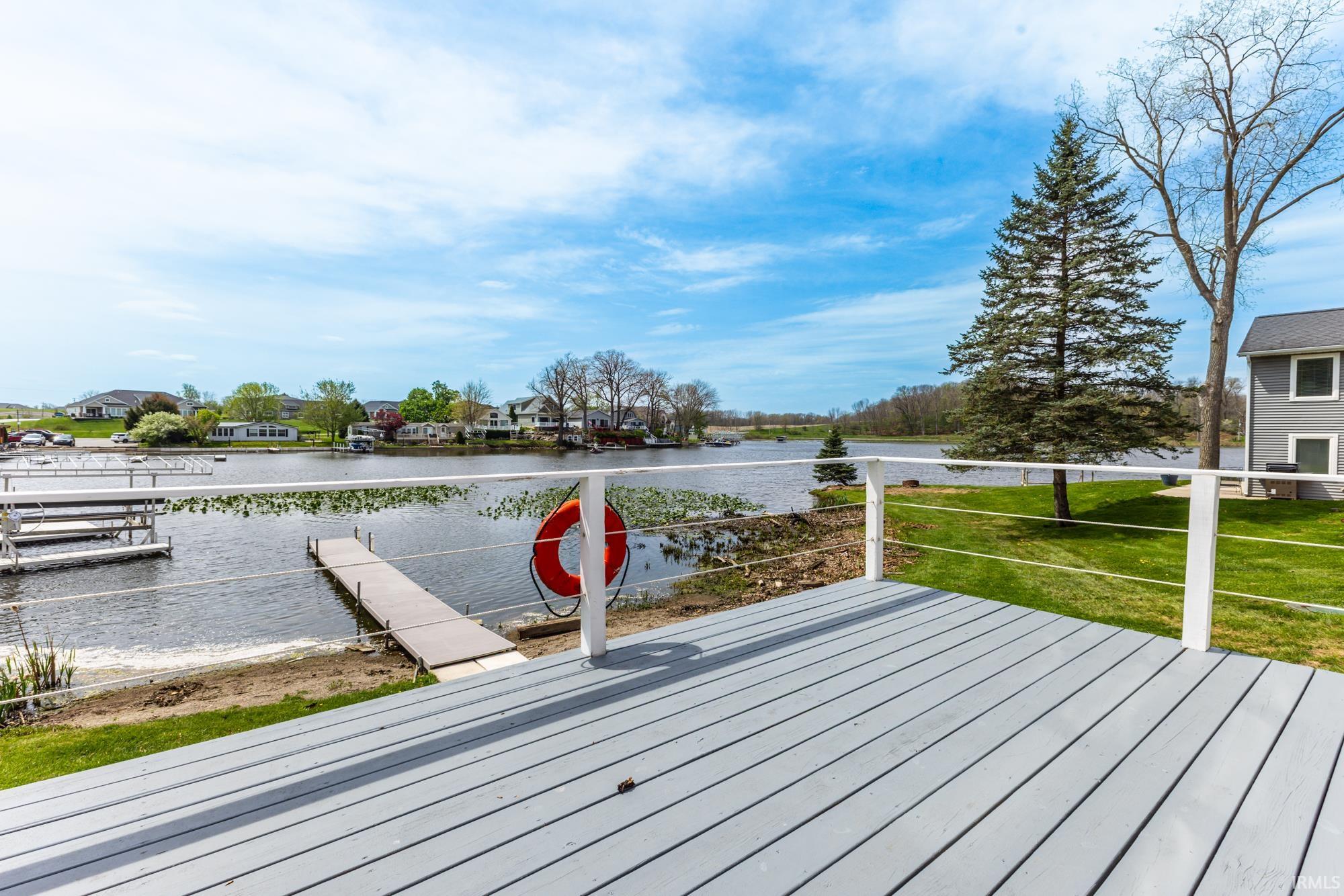 Expansive deck with gray wood-finish flooring and white cable railings