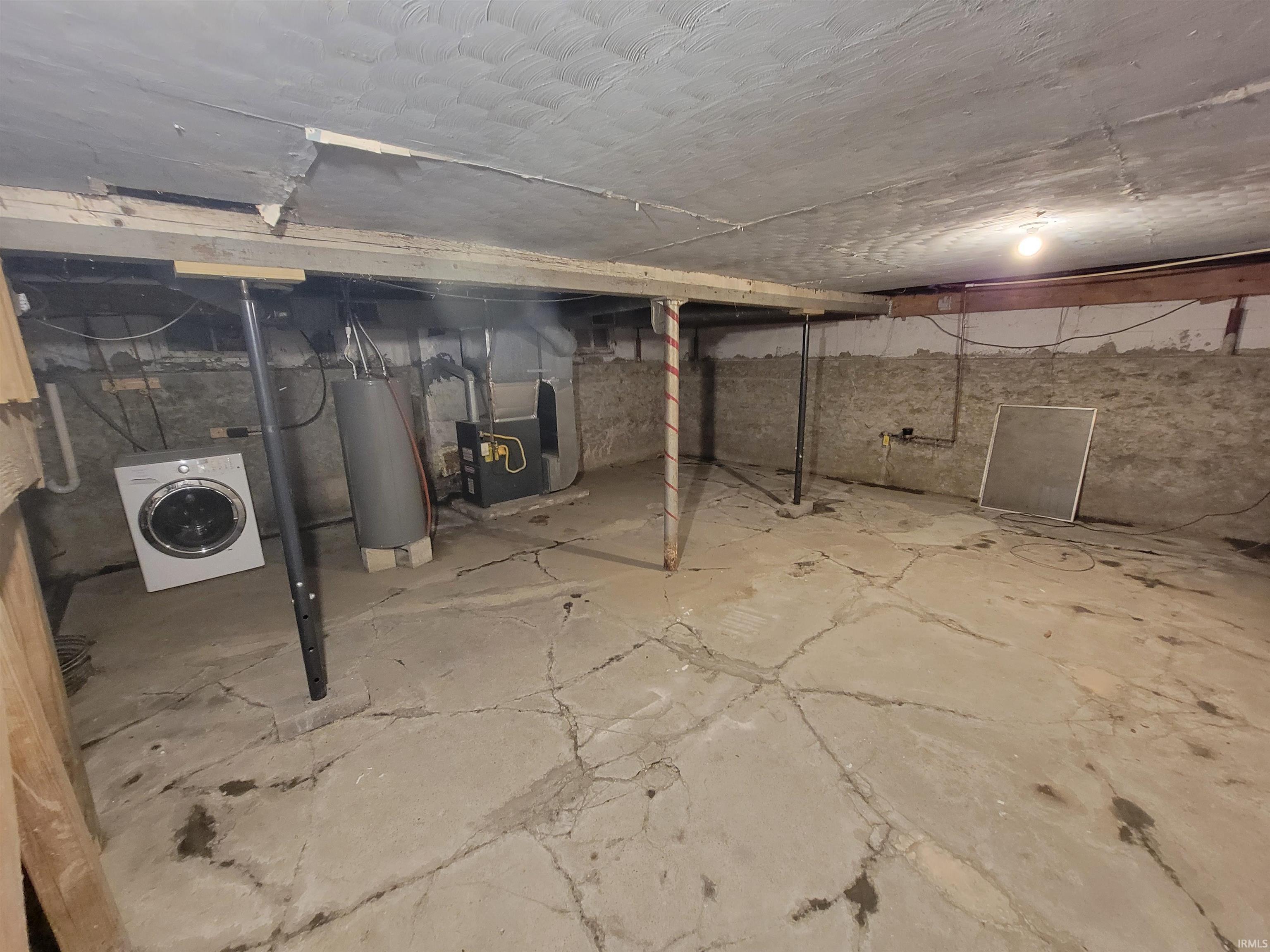Unfinished basement with concrete flooring and exposed ceiling joists