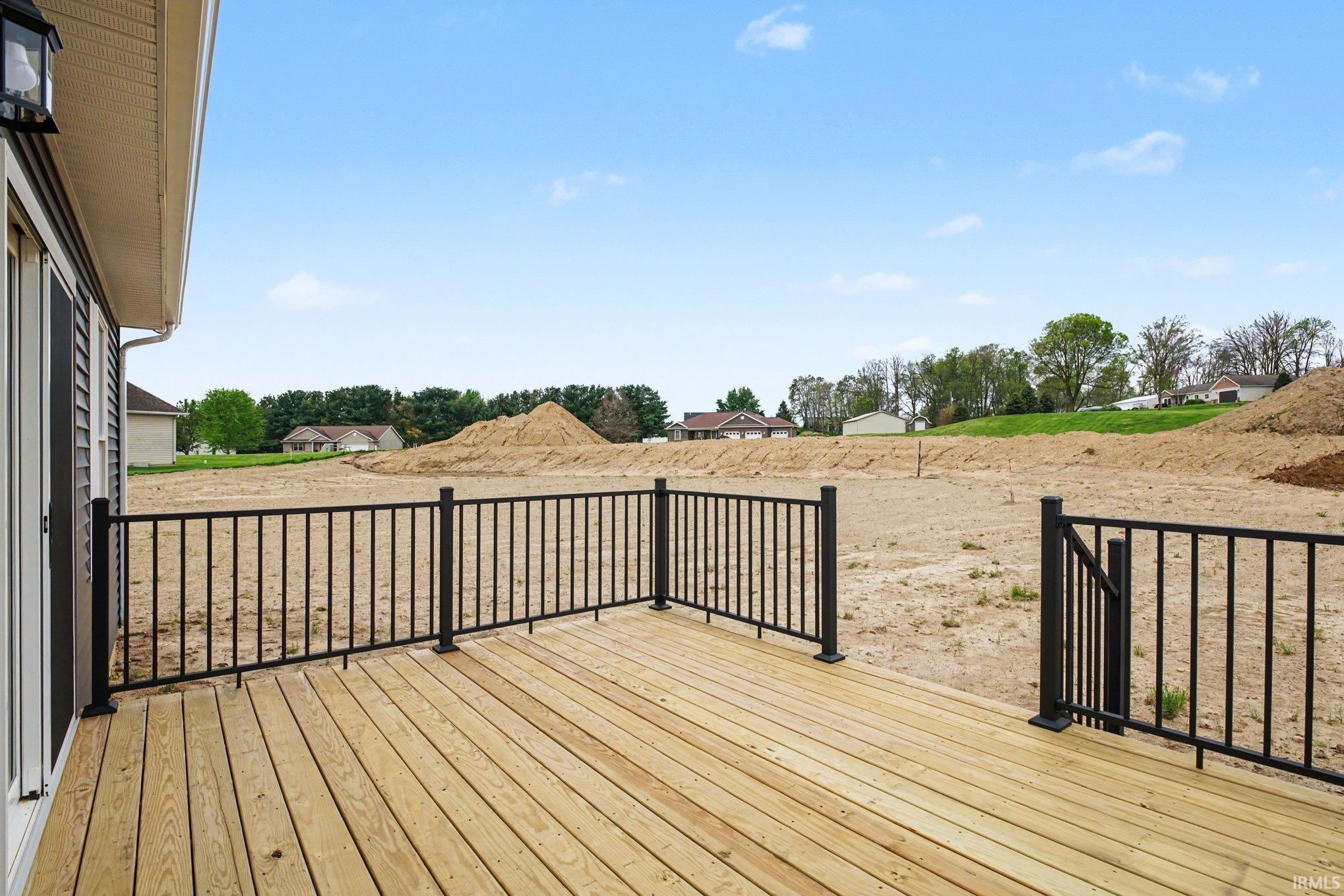 New construction deck featuring natural wood planks and black metal railings