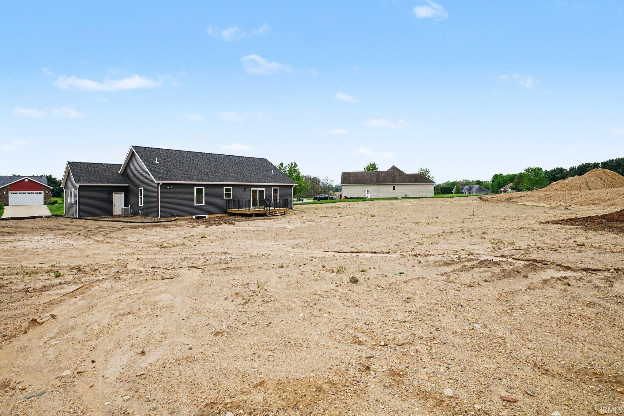 Rear exterior featuring dark gray siding, a charcoal shingled roof, and white trim accents