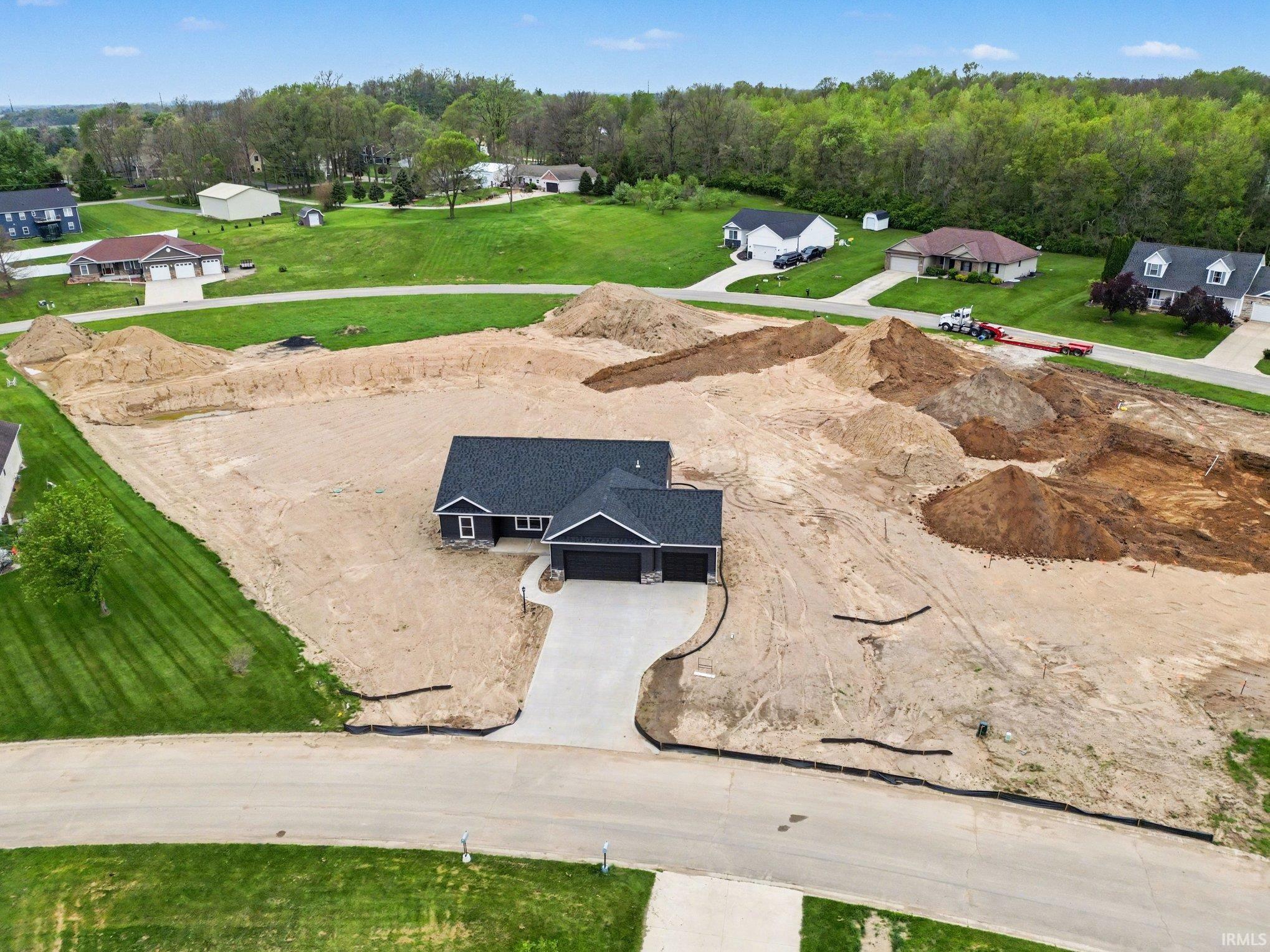 Newly constructed residence featuring a dark facade with light trim, an attached two-car garage, and a concrete driveway