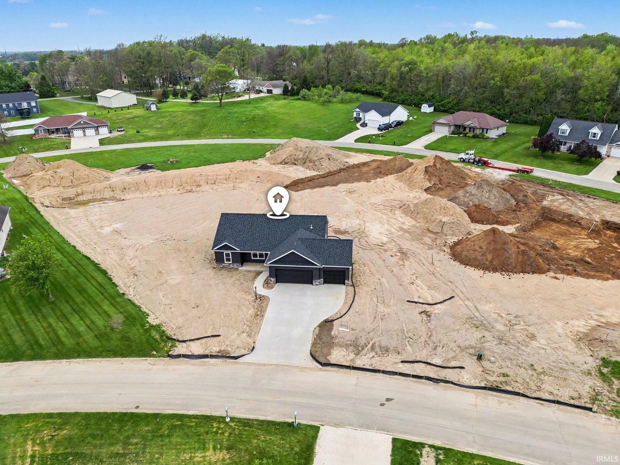 Newly constructed residence featuring a dark siding exterior with white trim accents and a dark shingled roof