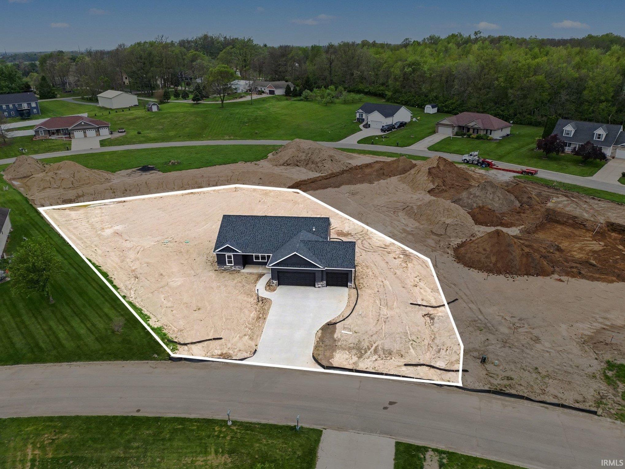 Newly constructed residence featuring a dark gray exterior with white trim, an attached two-car garage, and a paved driveway