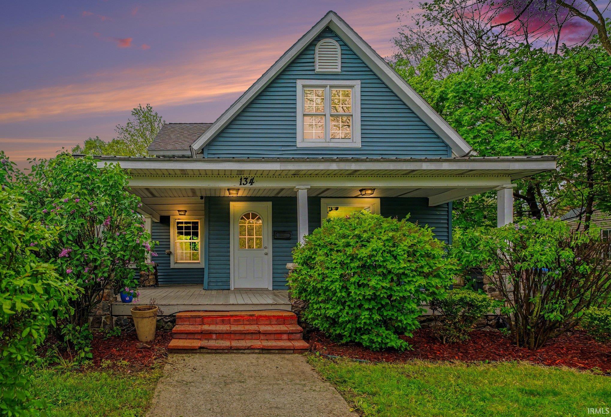 Gable-front home featuring blue horizontal siding and white trim