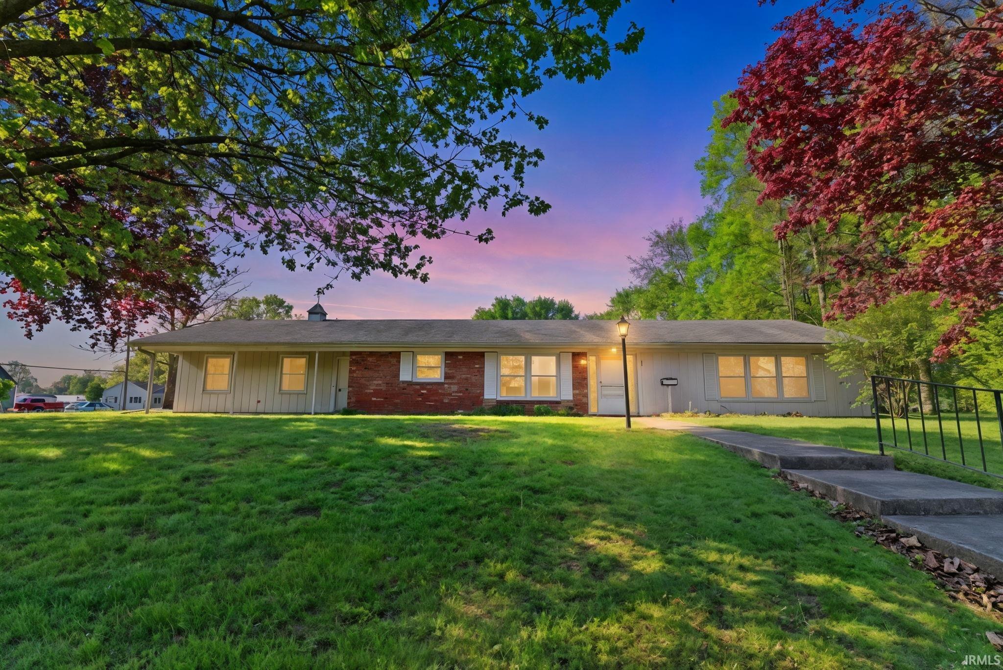 Ranch-style residence featuring a brick facade accent and light-colored siding