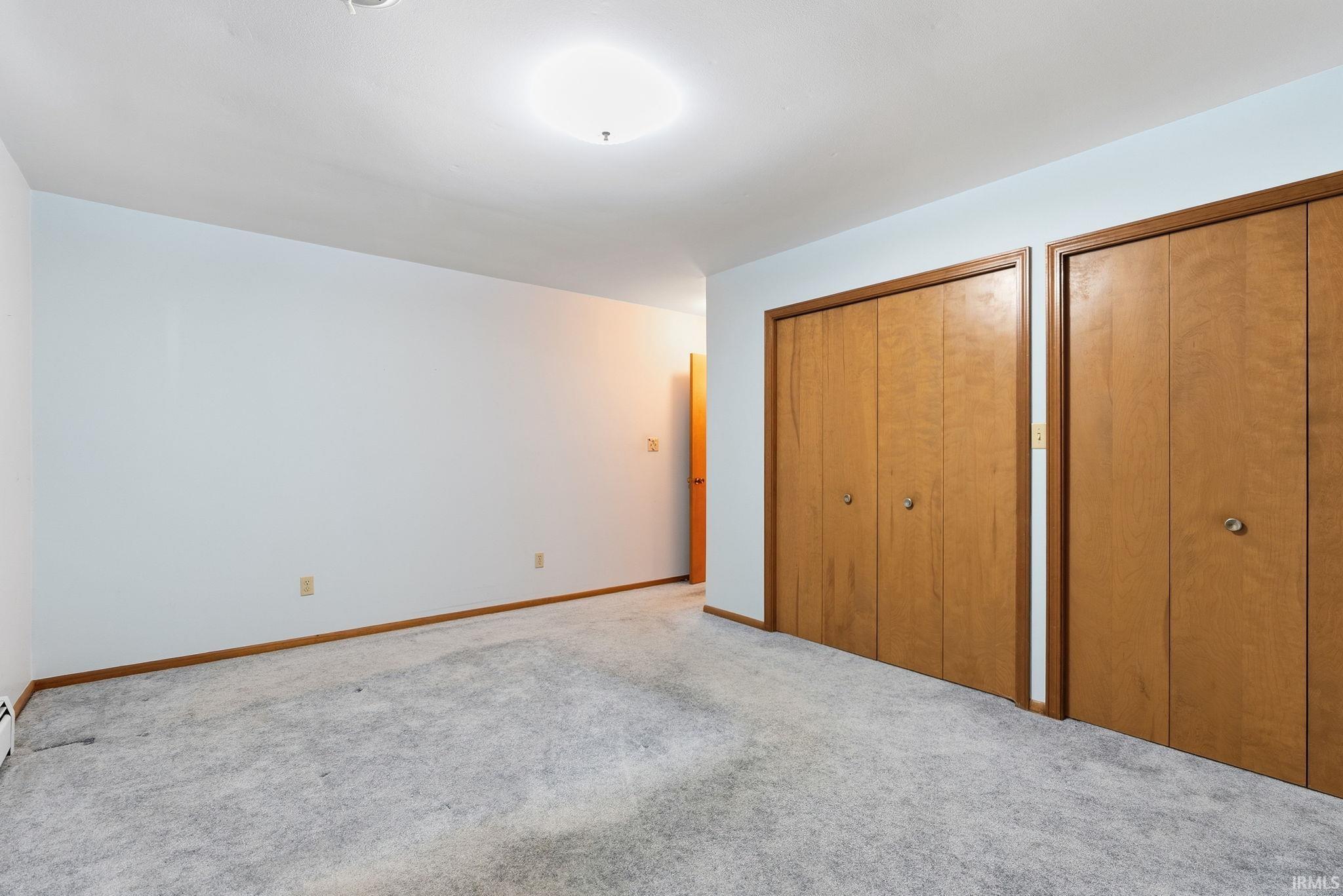 Light-toned carpeting with wood-finish baseboards and door frames