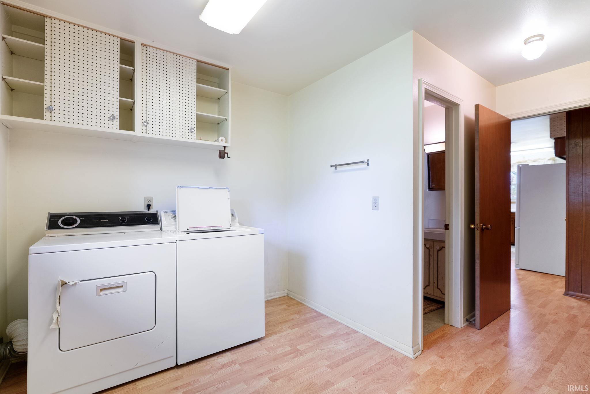 Laundry area featuring upper cabinetry with sliding perforated doors