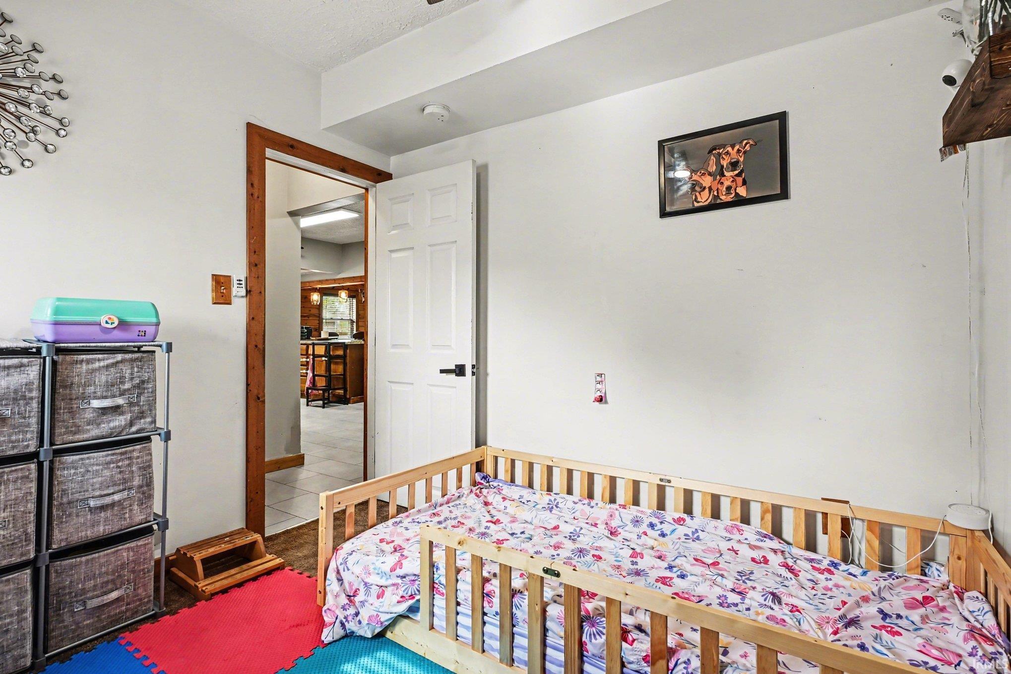 Interior room with white walls, wood-trimmed doorway, and white paneled door with black hardware