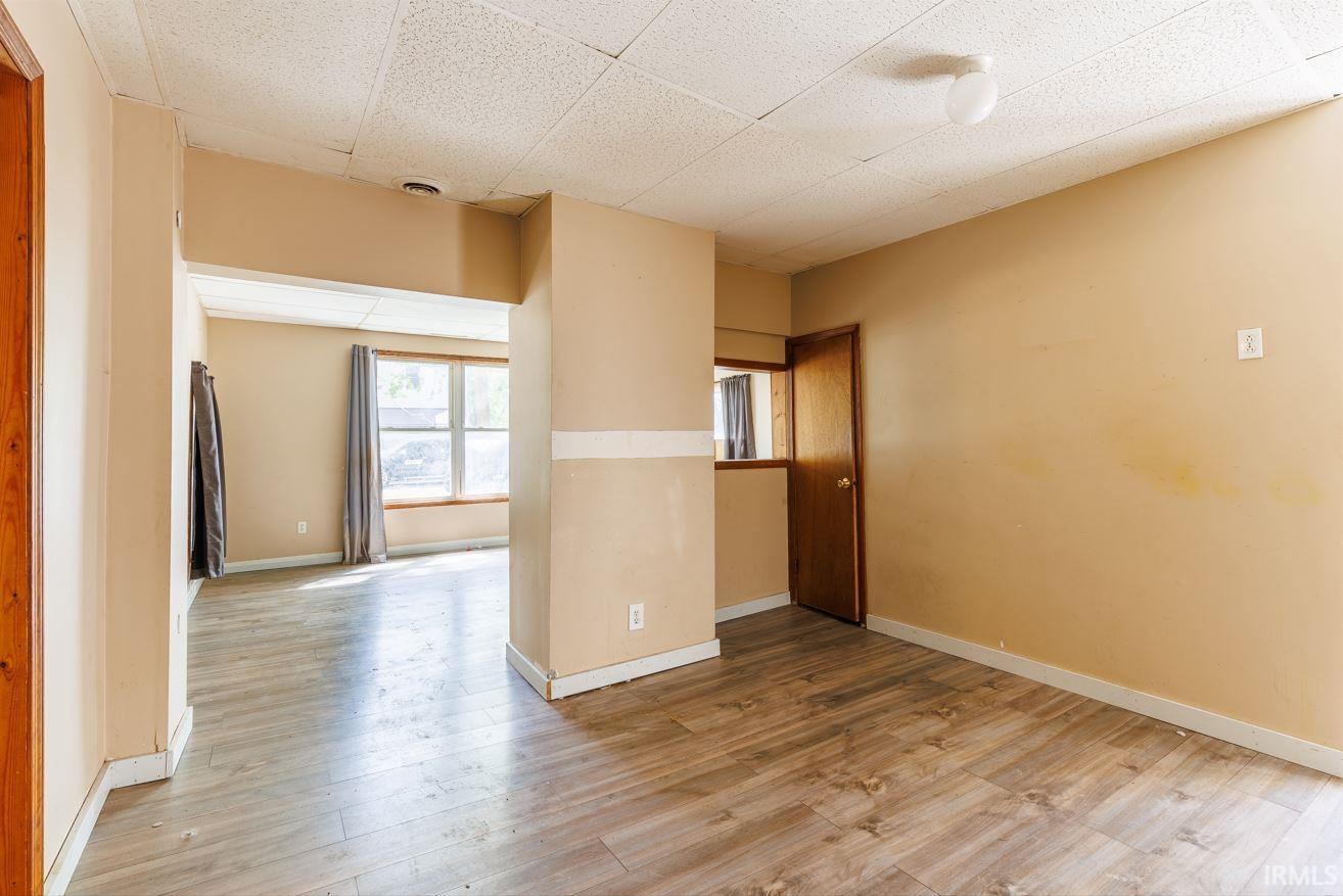 Spacious room with wood-finish flooring and neutral-toned walls