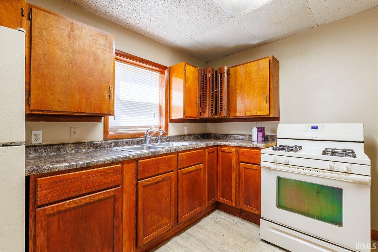Kitchen featuring wood-finish cabinetry and a double basin stainless steel sink