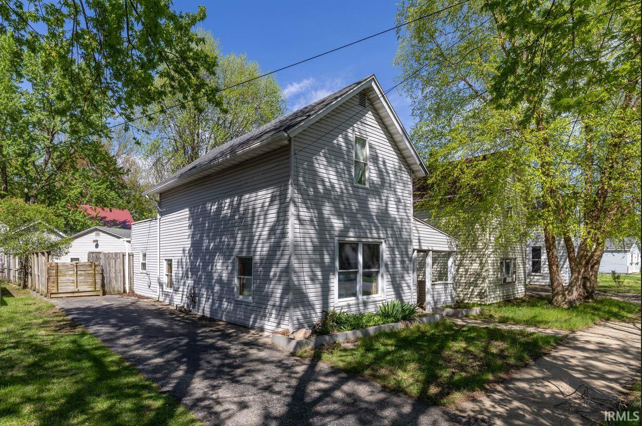 Two-story residence featuring light-colored siding and a gabled roofline