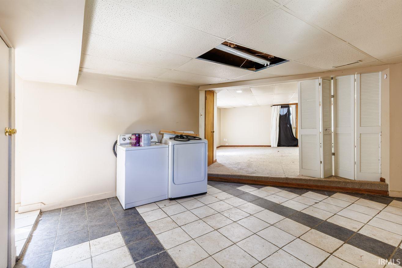 Tiled flooring with a contrasting stripe pattern defines this adaptable space, offering distinct areas for various uses