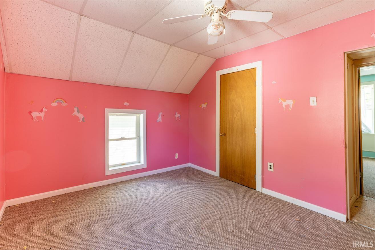 Interior room featuring pink walls, a single window with white trim, and a ceiling fan