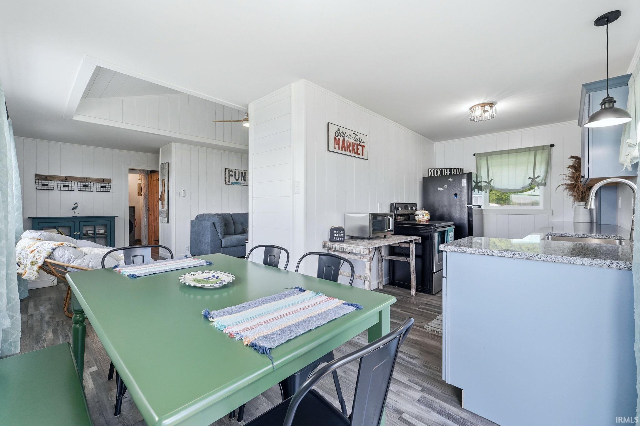 Open-concept dining and kitchen area featuring wood-finish flooring